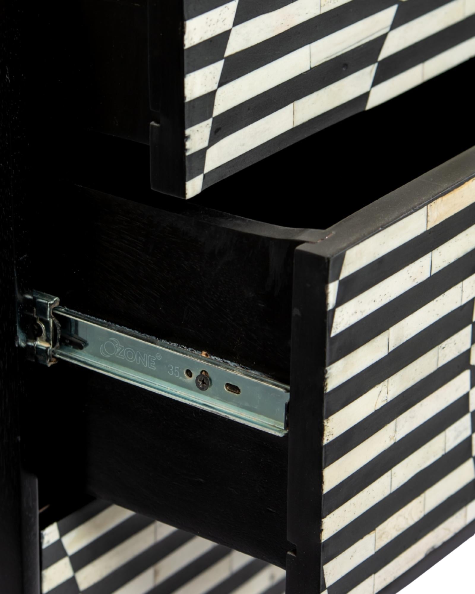 Black and white geometric bone inlay chest of drawers with gold base.