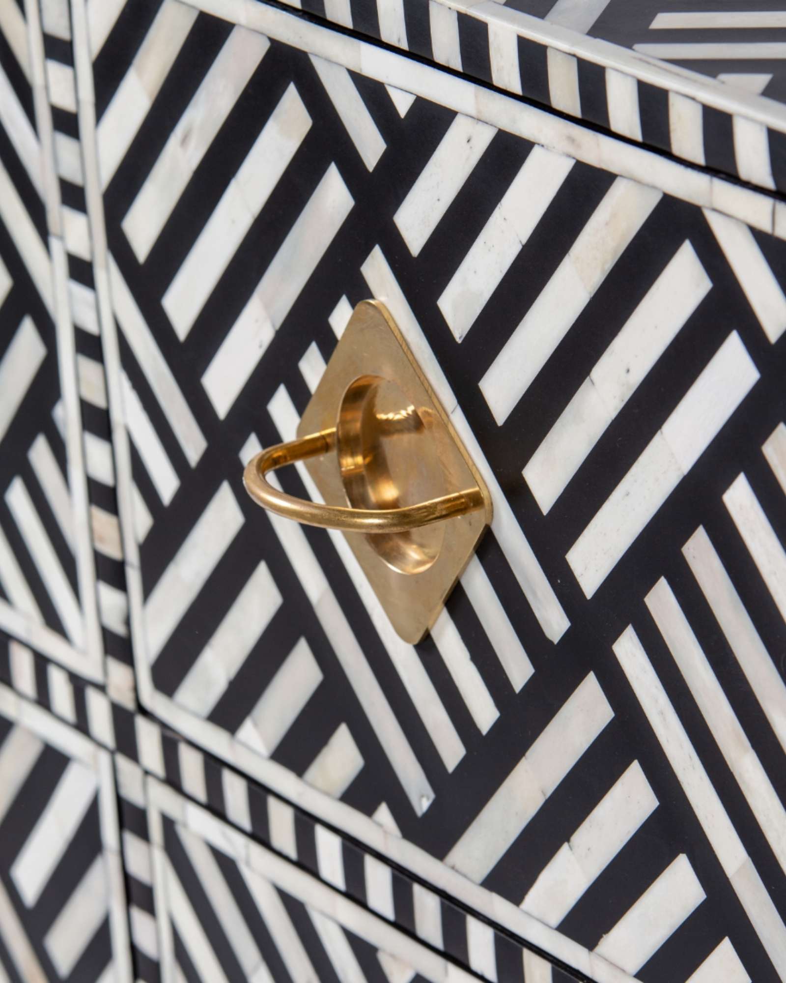 Luxury black and white bone inlay chest of drawers with brass accents and geometric design, handcrafted for statement interiors.