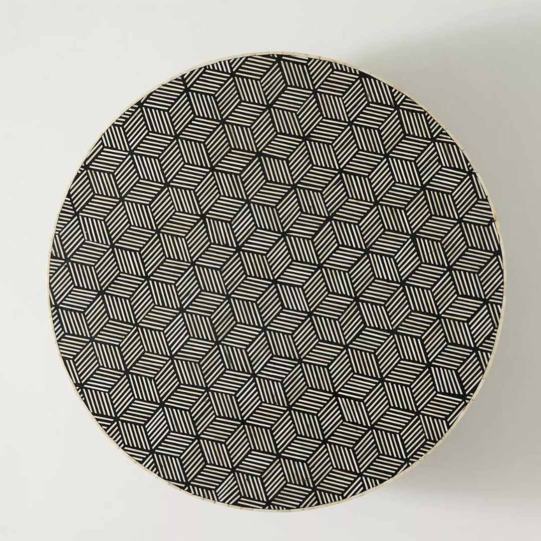 Round black bone inlay coffee table with a bold geometric pattern and gold base. A modern centerpiece for elegant living spaces.