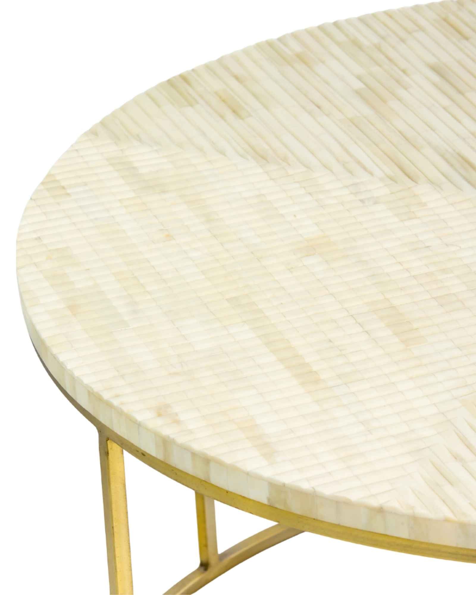 Ivory bone carved coffee table with linear textured pattern and gold metal circular frame by Tabeer Homes.