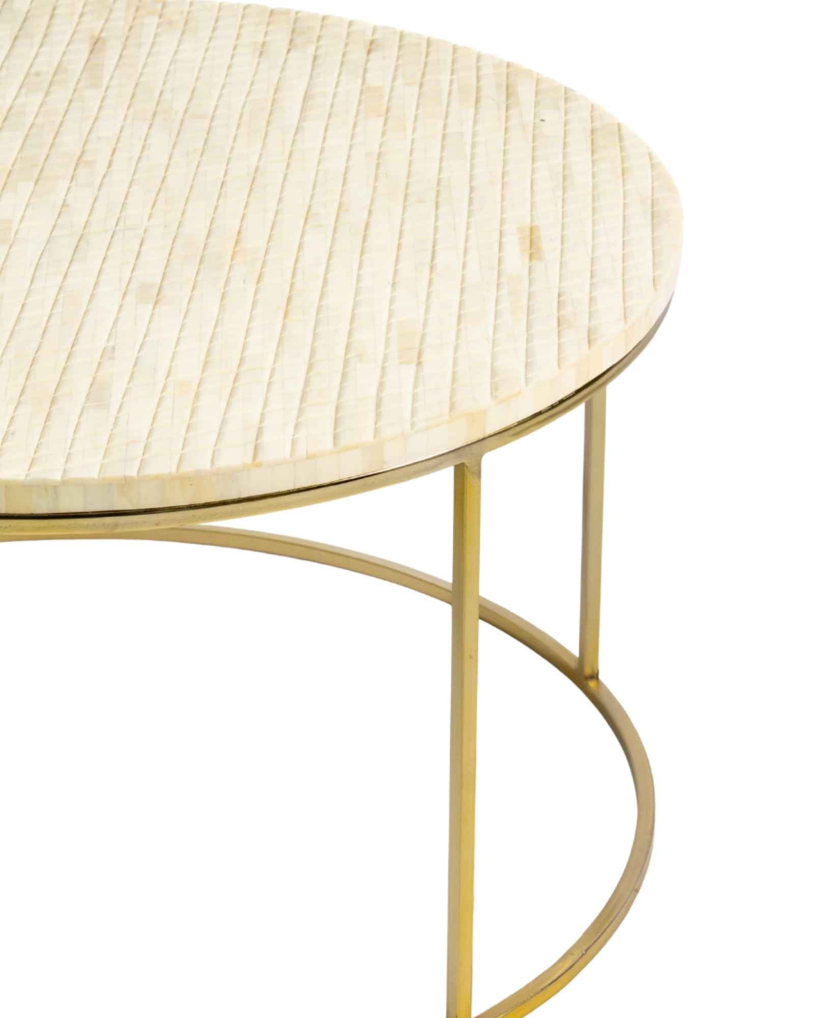 Ivory bone carved coffee table with linear textured design and brushed gold circular metal base by Tabeer Homes.