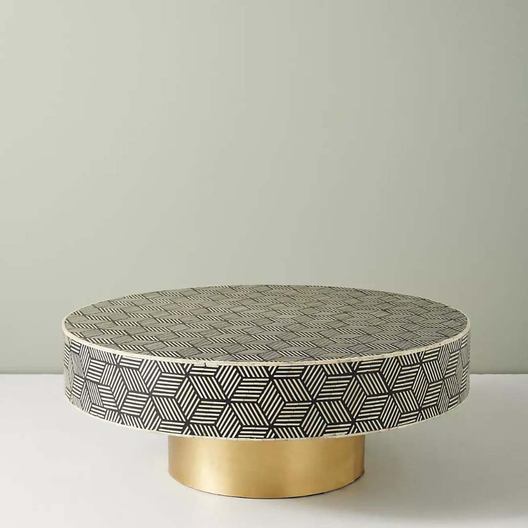 Round black bone inlay coffee table with a bold geometric pattern and gold base. A modern centerpiece for elegant living spaces.