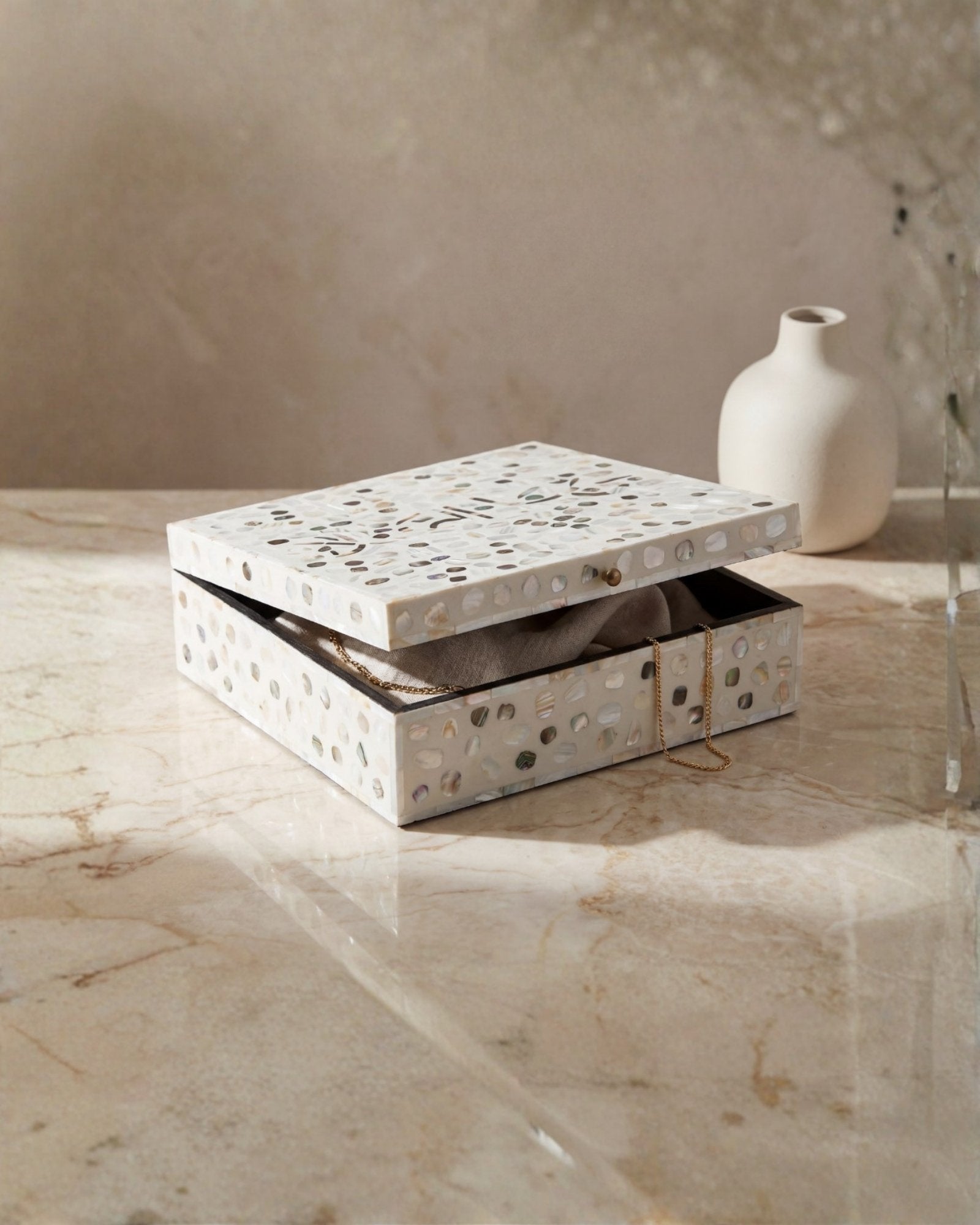 Mother of pearl inlay box featuring textured mosaic pattern in white and multitone, handcrafted decor piece.