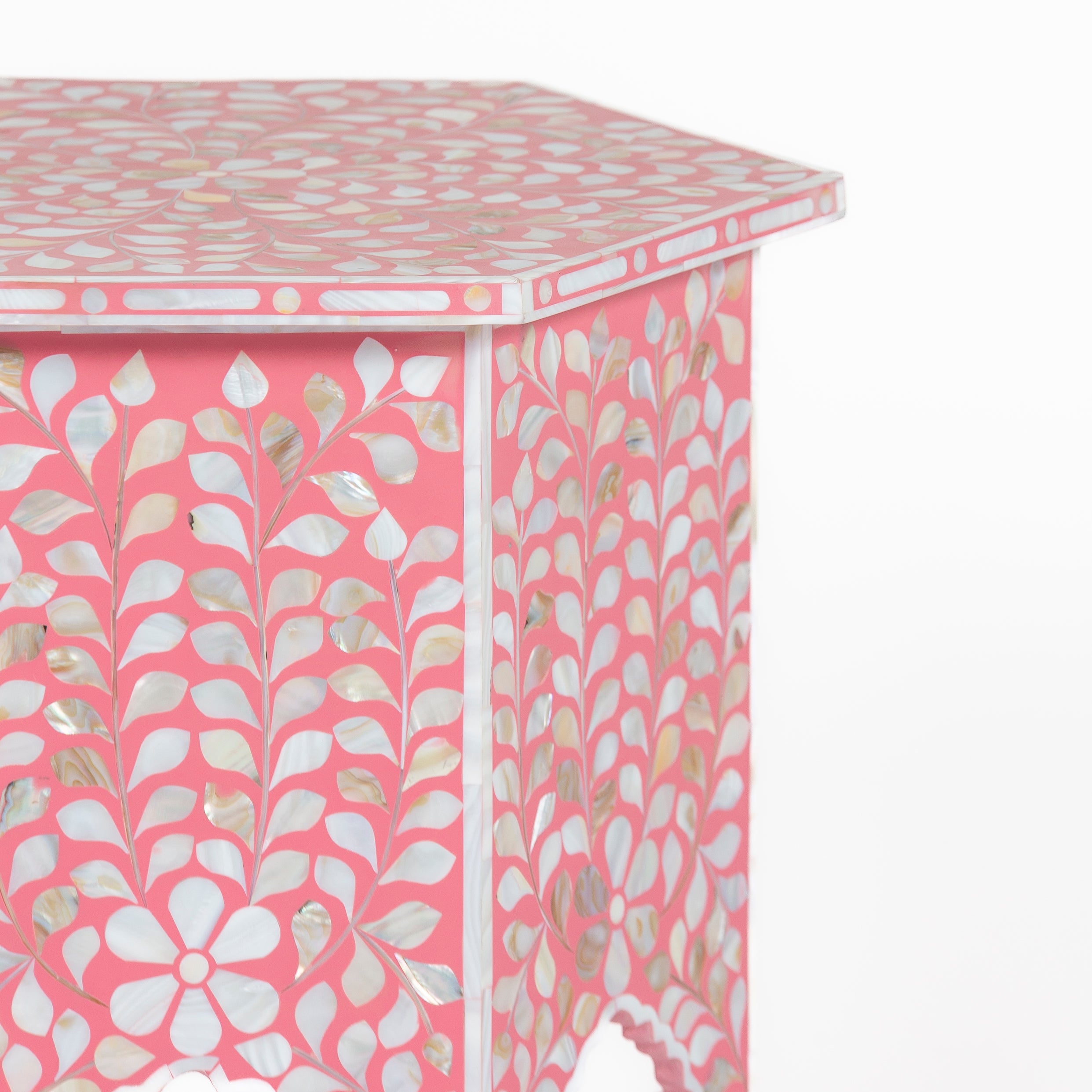 Handcrafted Iris side table featuring pink mother of pearl inlay with a hexagonal silhouette, floral detailing, and arched legs.