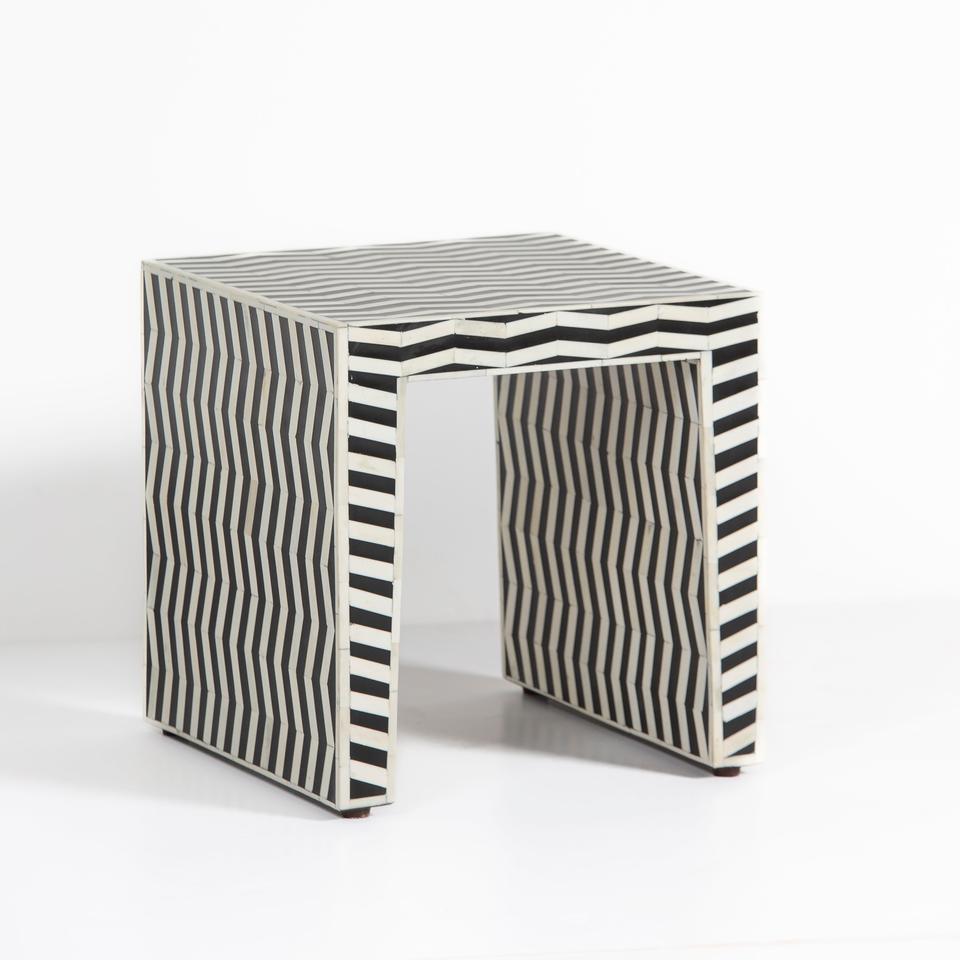 Handcrafted Isra side table featuring black bone inlay with geometric striped detailing and a compact cubic form.