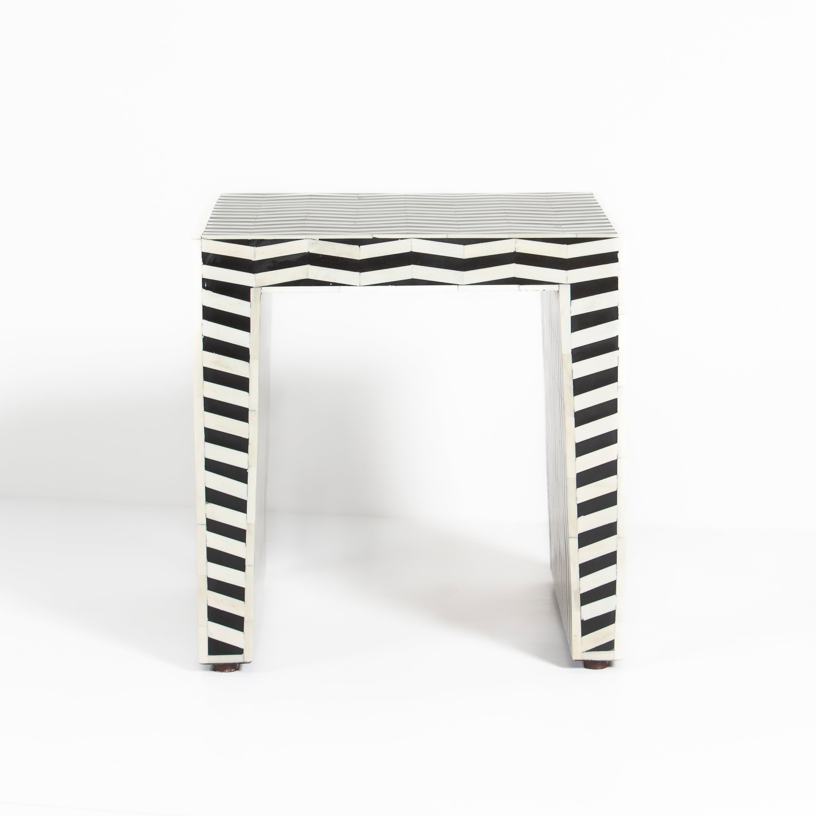 Handcrafted Isra side table featuring black bone inlay with geometric striped detailing and a compact cubic form.