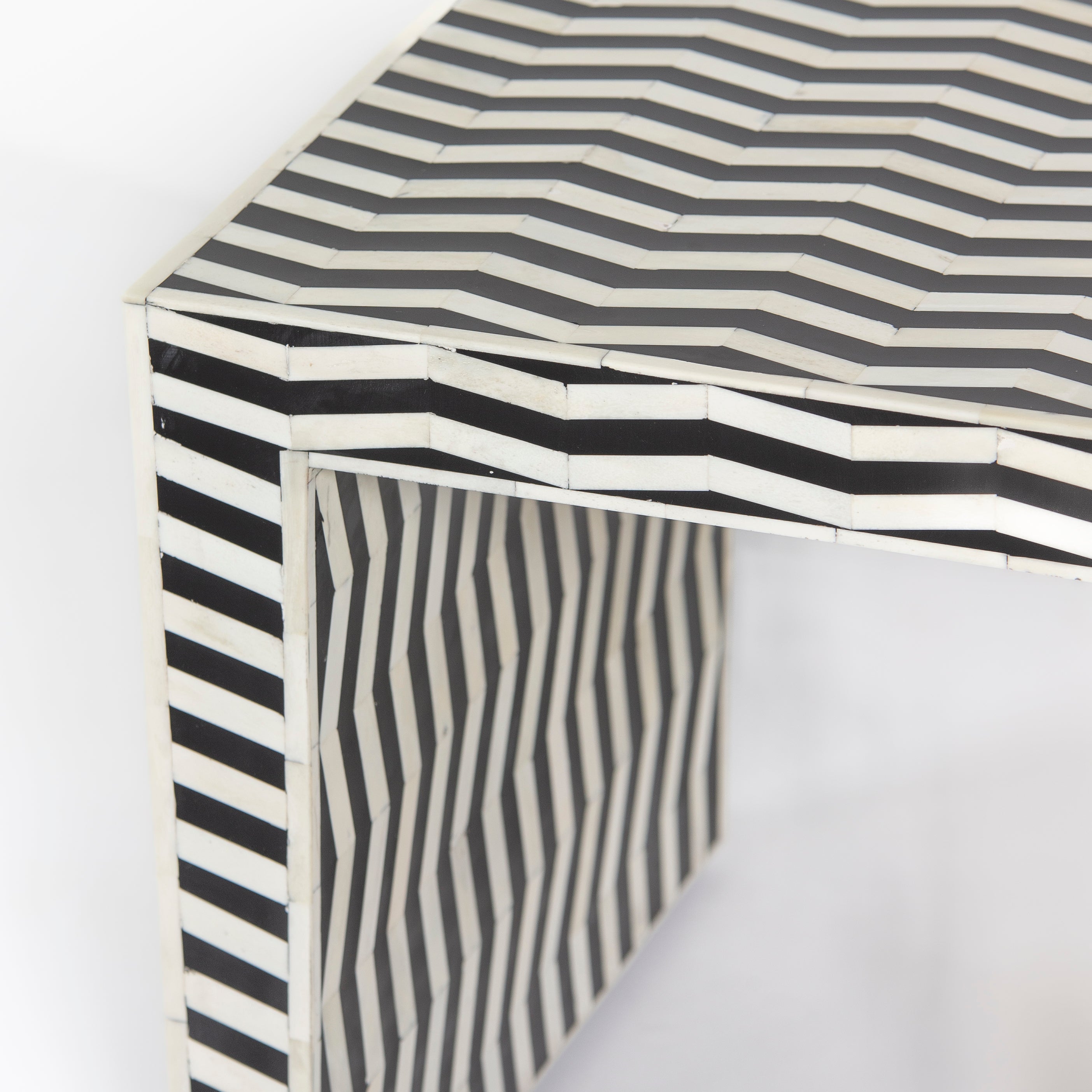 Handcrafted Isra side table featuring black bone inlay with geometric striped detailing and a compact cubic form.