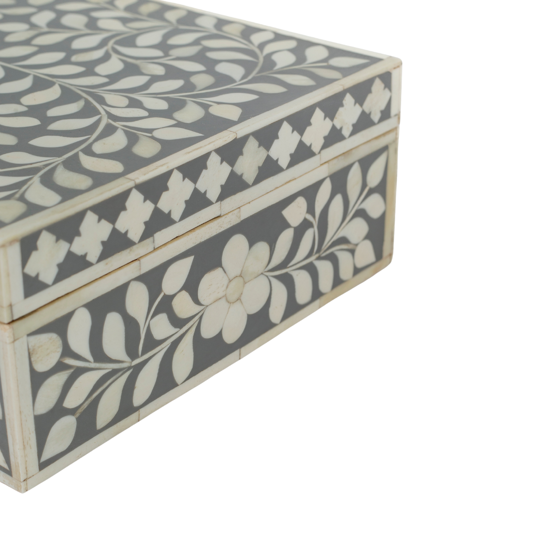 A soft grey decorative box crafted in bone inlay, combining subtle tones with intricate floral detailing.