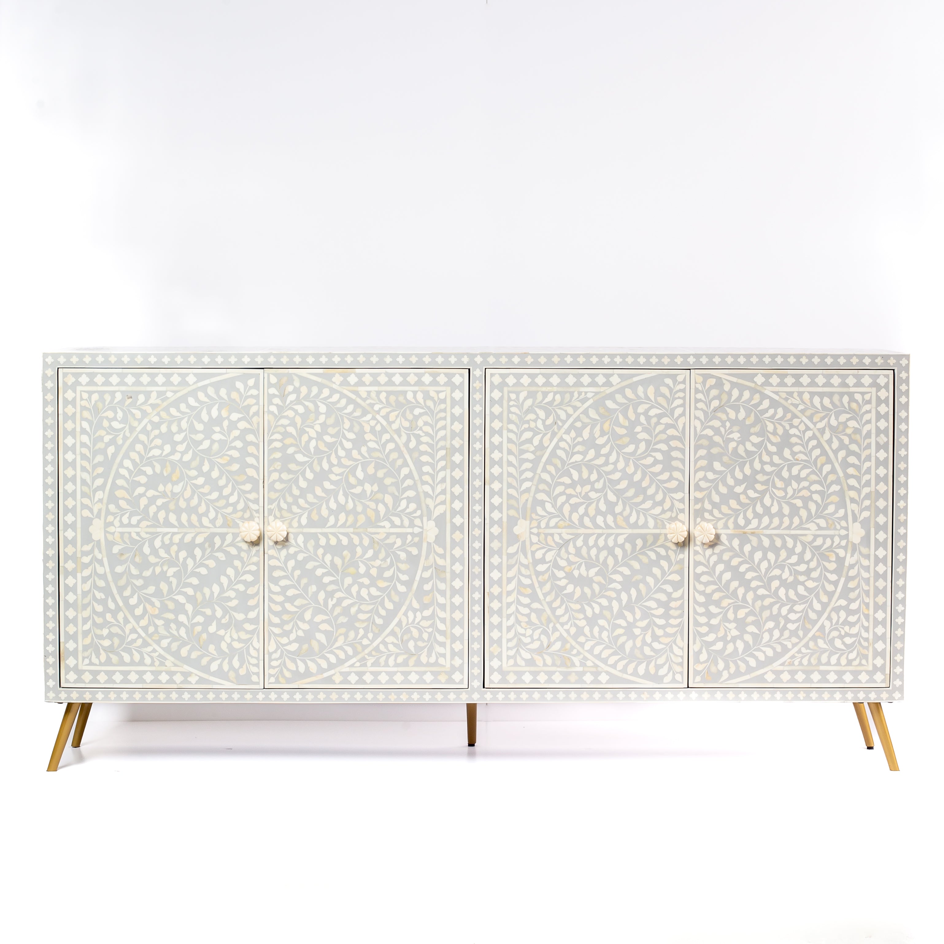 Grey bone inlay cabinet with floral vine pattern, brass legs, and carved bone knobs, handcrafted with spacious storage and artisanal charm.