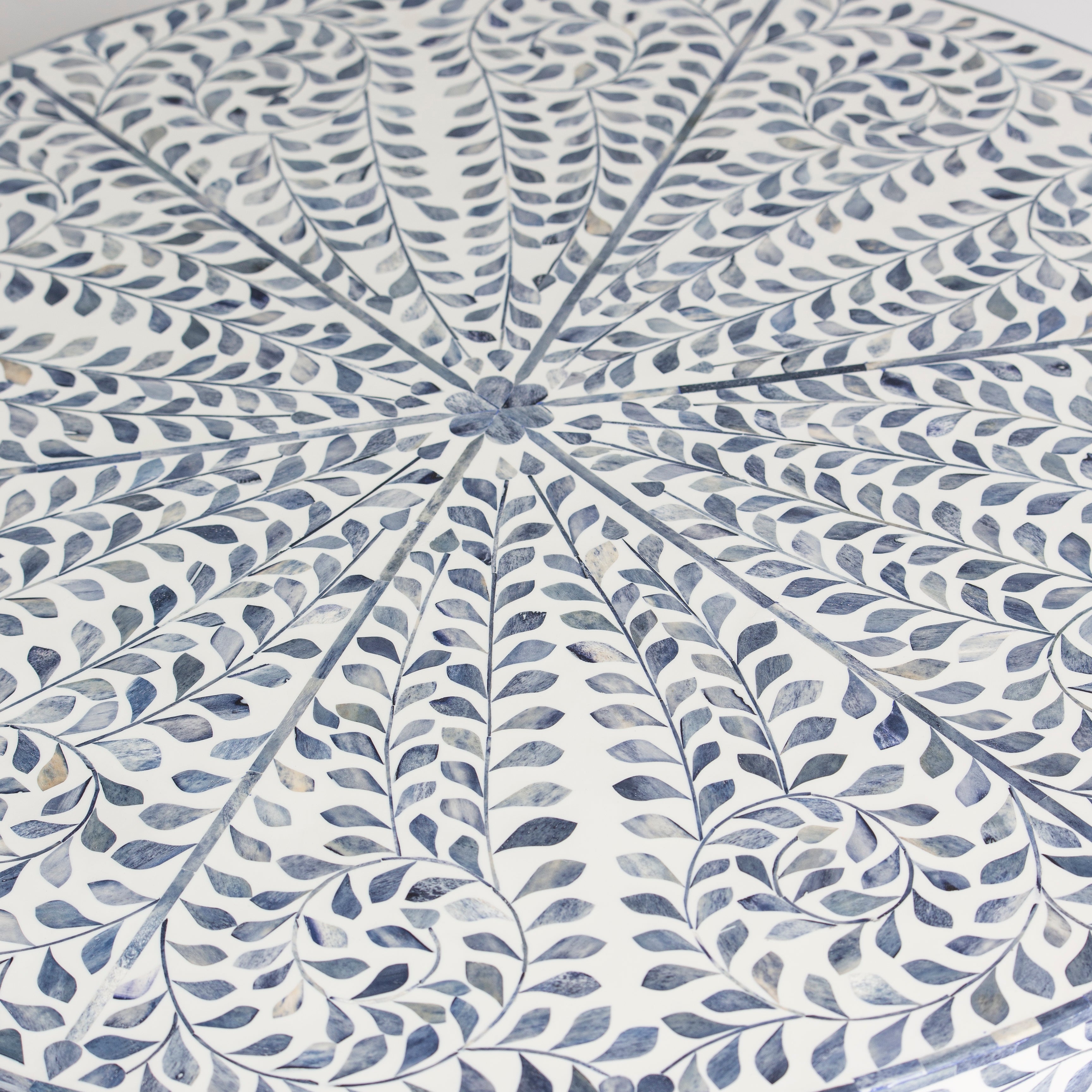 Handcrafted Jade coffee table featuring intricate blue bone inlay detailing with a round silhouette and brushed brass base.