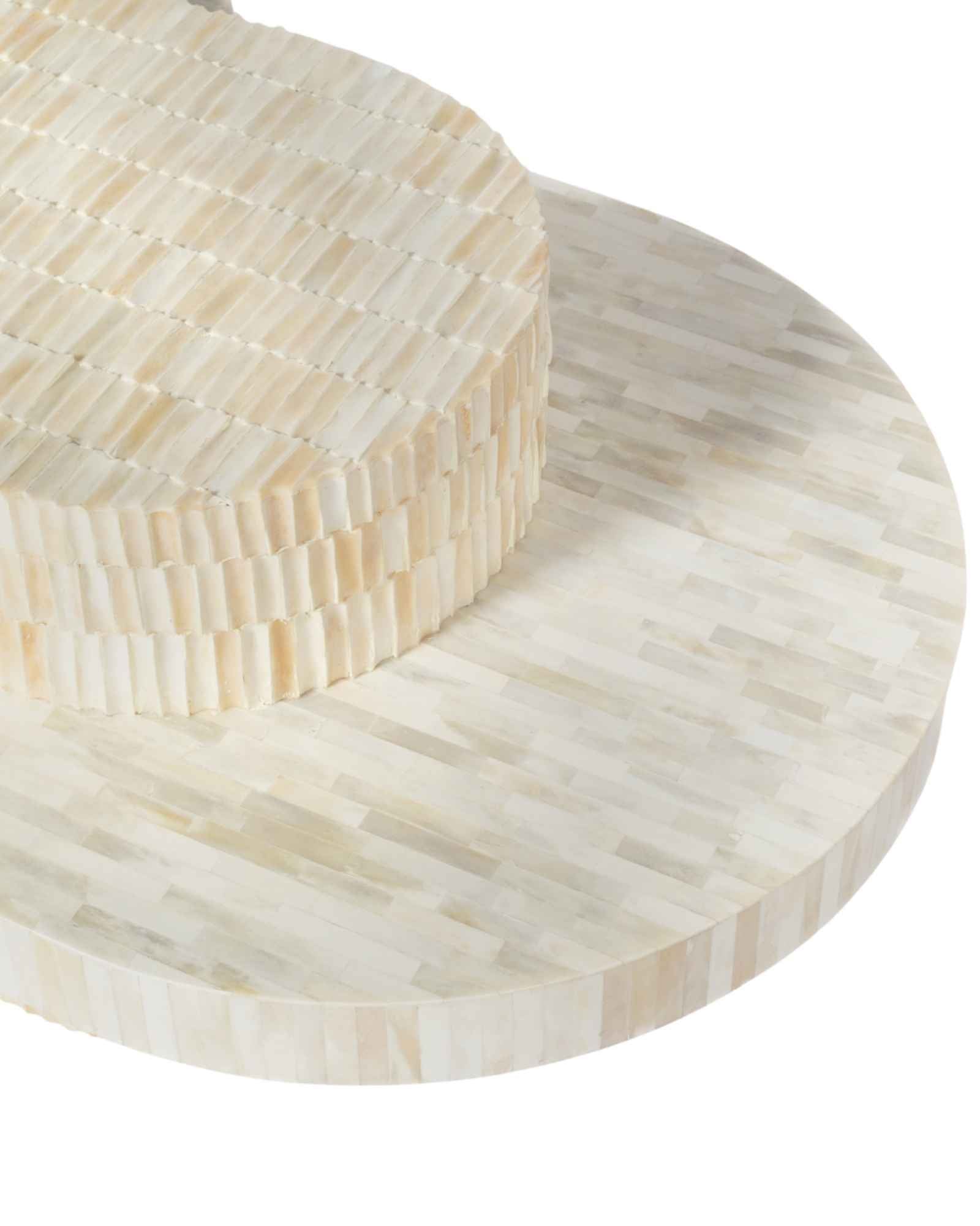 Sculptural bone carved coffee table with layered design in soft neutral tones, handcrafted with curved tiers and textured artisanal detailing.