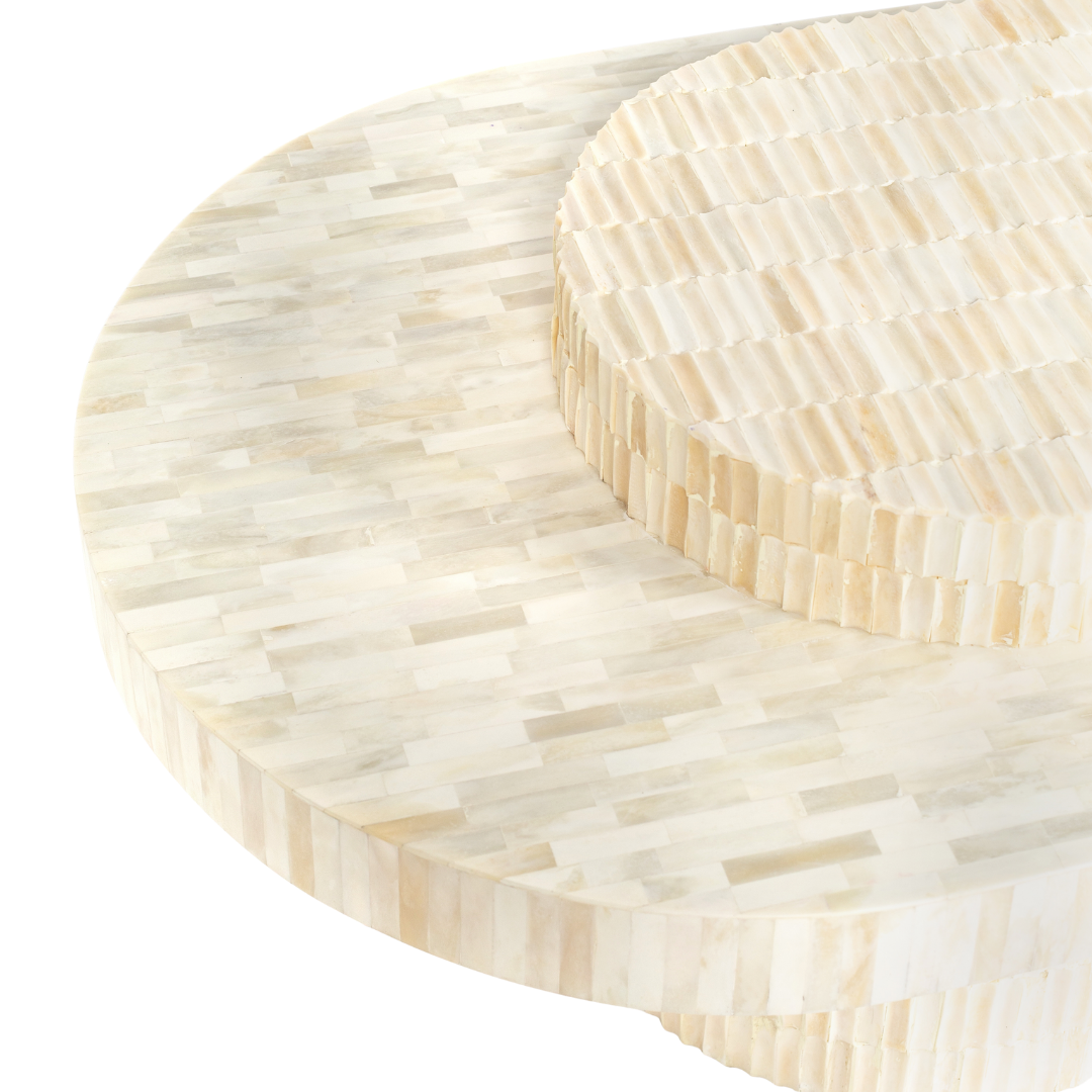 Sculptural bone carved coffee table with layered design in soft neutral tones, handcrafted with curved tiers and textured artisanal detailing.