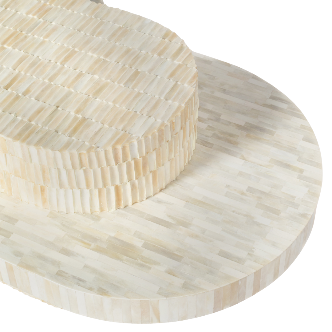 Sculptural bone carved coffee table with layered design in soft neutral tones, handcrafted with curved tiers and textured artisanal detailing.