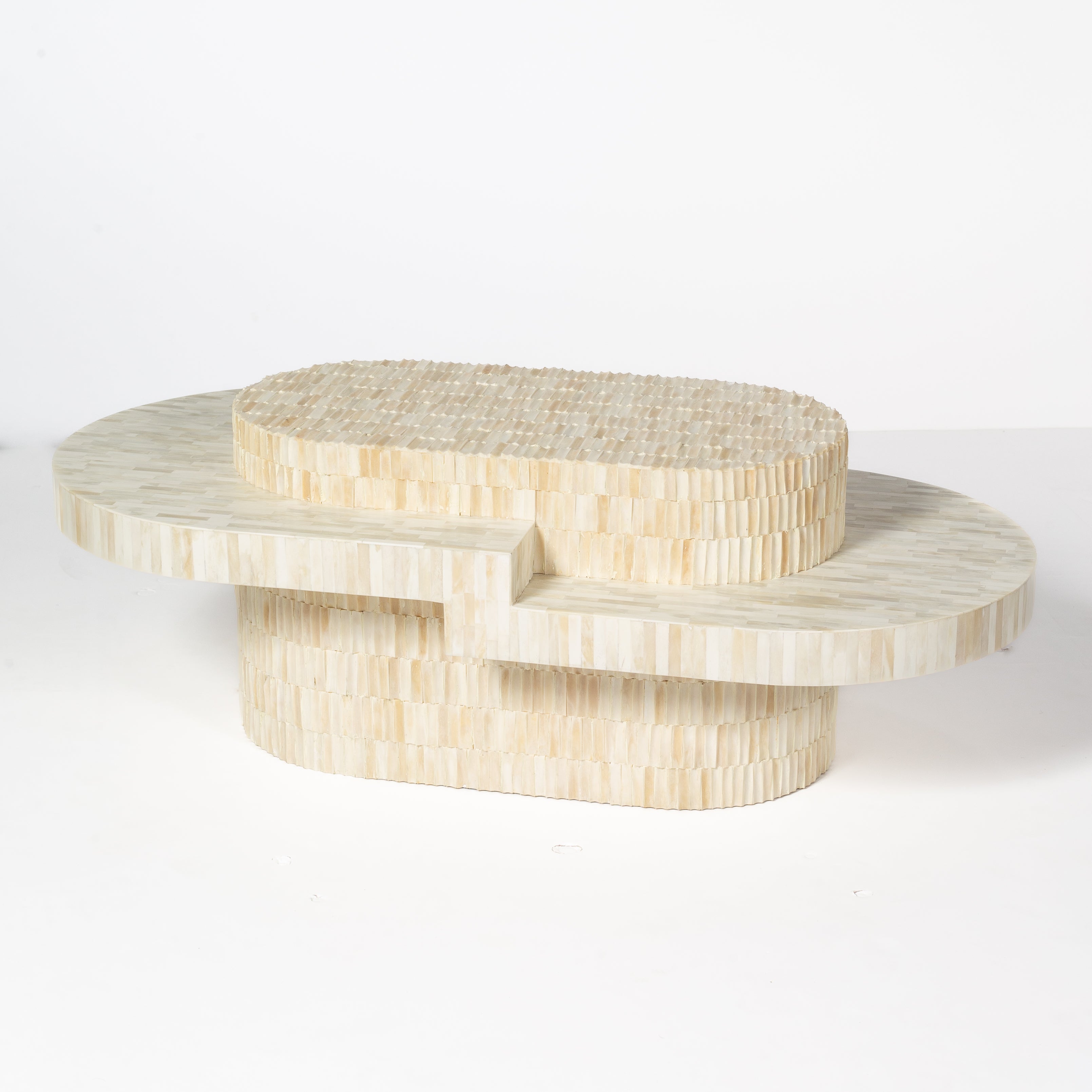 Sculptural bone carved coffee table with layered design in soft neutral tones, handcrafted with curved tiers and textured artisanal detailing.