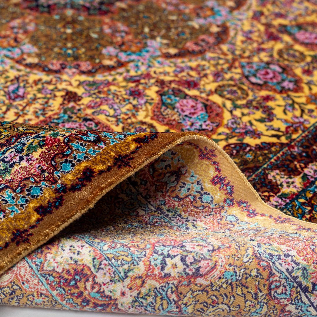 Golden silk rug with floral medallion center and wine-toned border, featuring intricate handmade detailing and vibrant color accents.