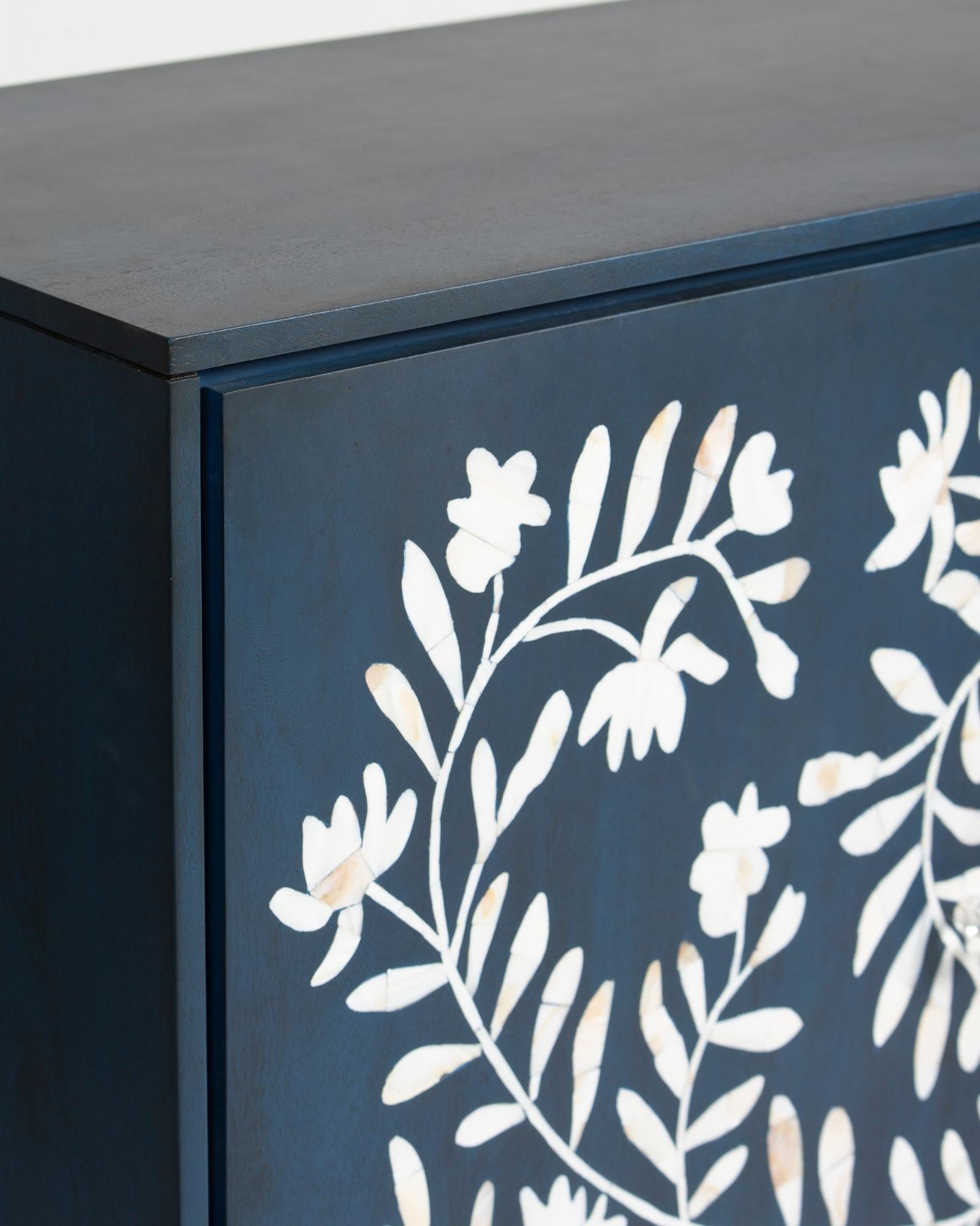 Mother of pearl inlay cabinet featuring intricate floral vine pattern in blue and white, handcrafted furniture piece.