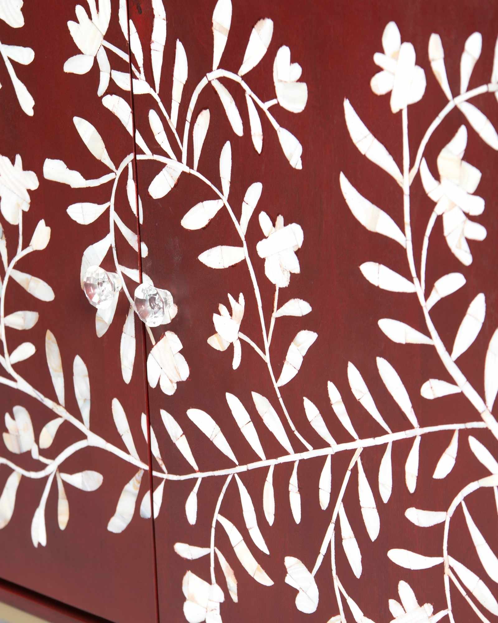 Mother of pearl inlay cabinet featuring intricate floral vine pattern in burgundy and white, handcrafted furniture piece.