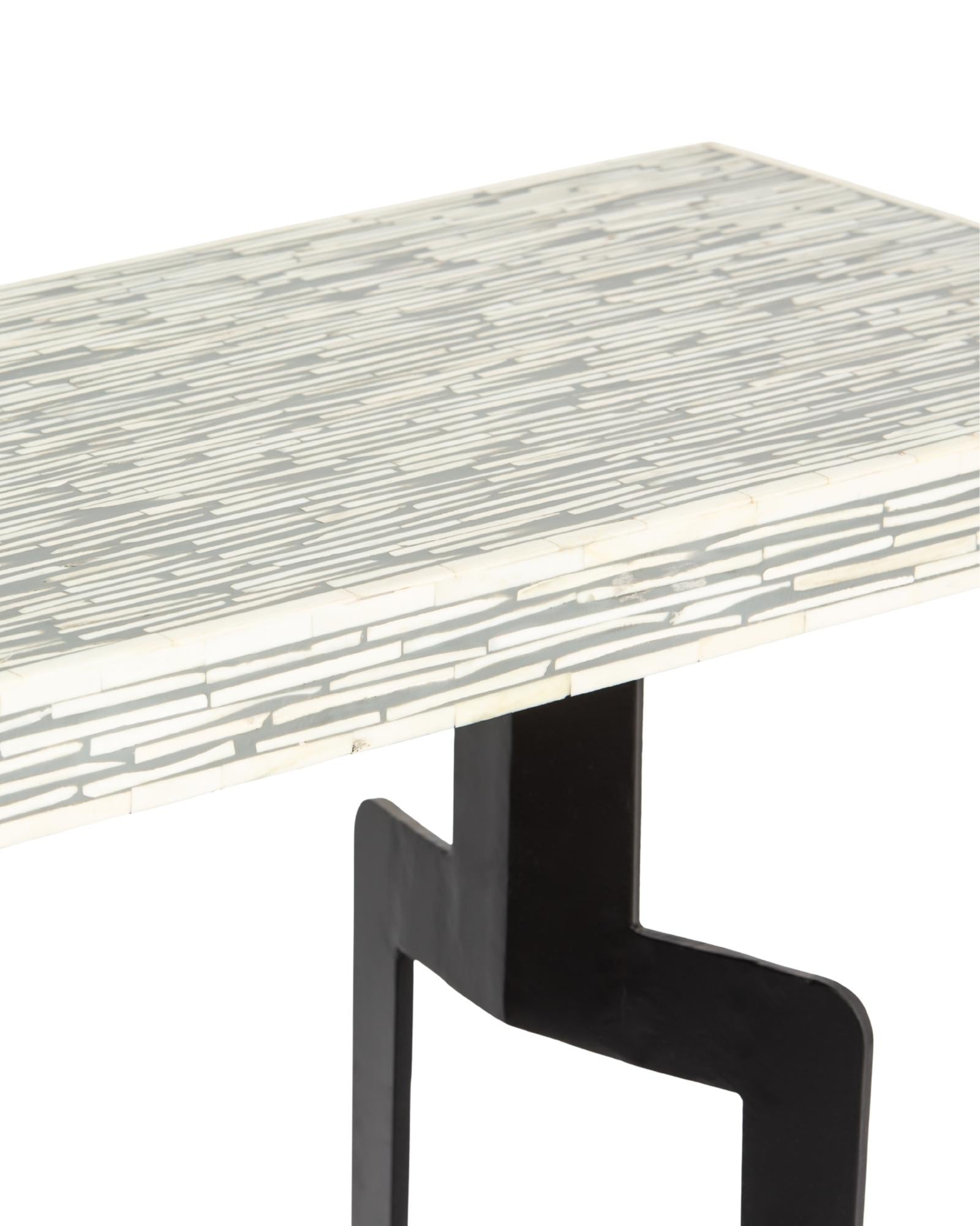 Table with bone inlay top and black legs on a white background