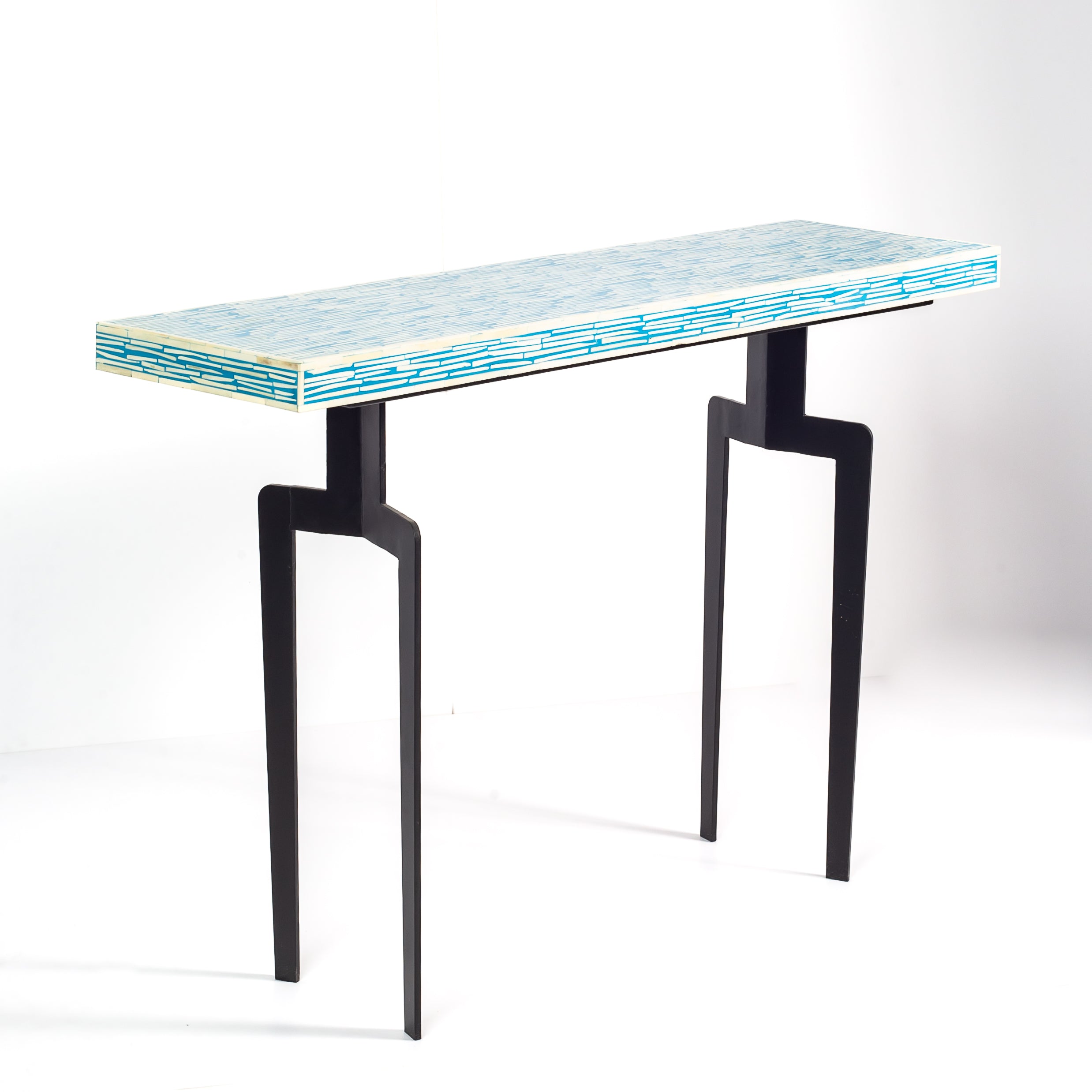 Modern console table with a blue and white patterned top on a white background