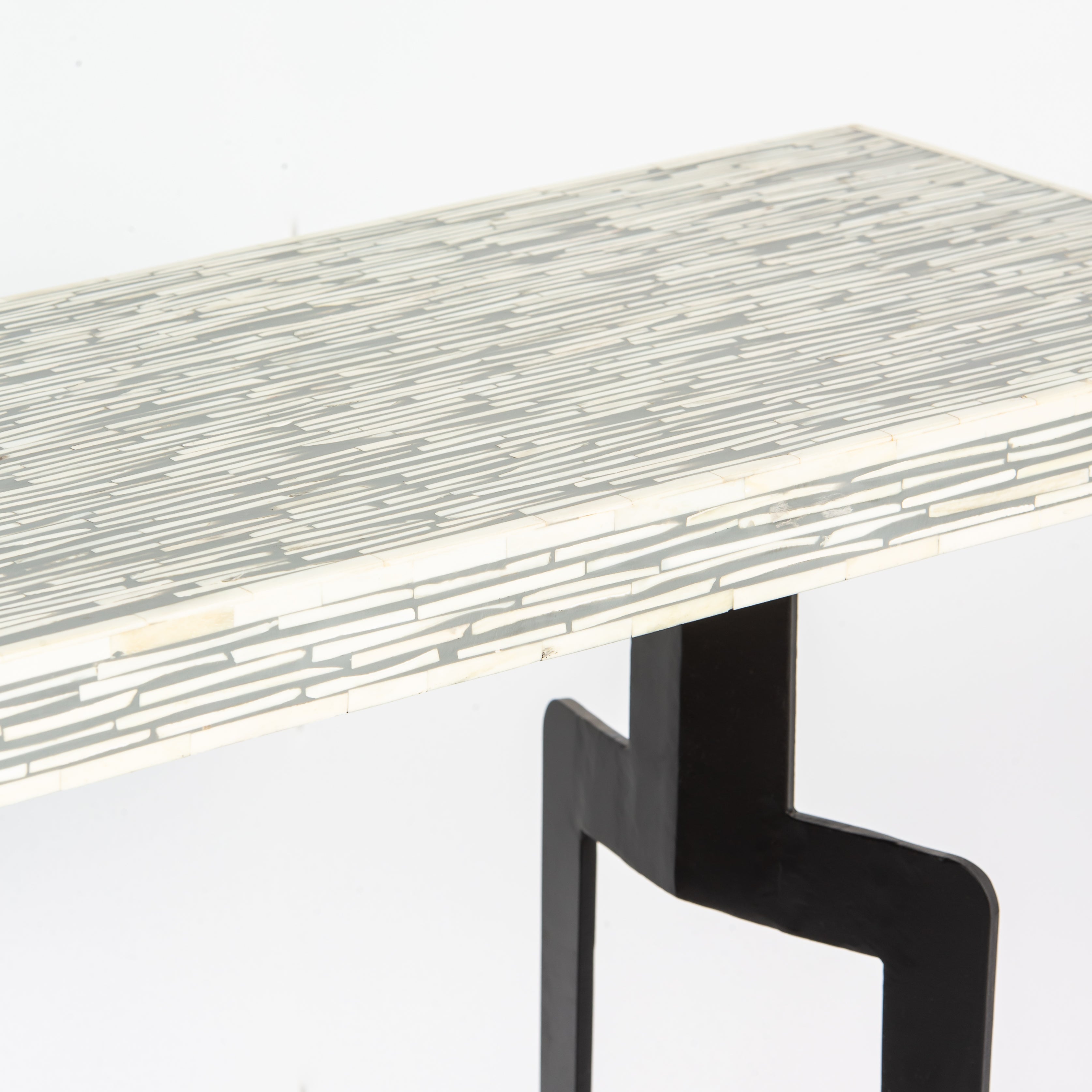 Table with a mosaic pattern on the surface and black legs on a white background
