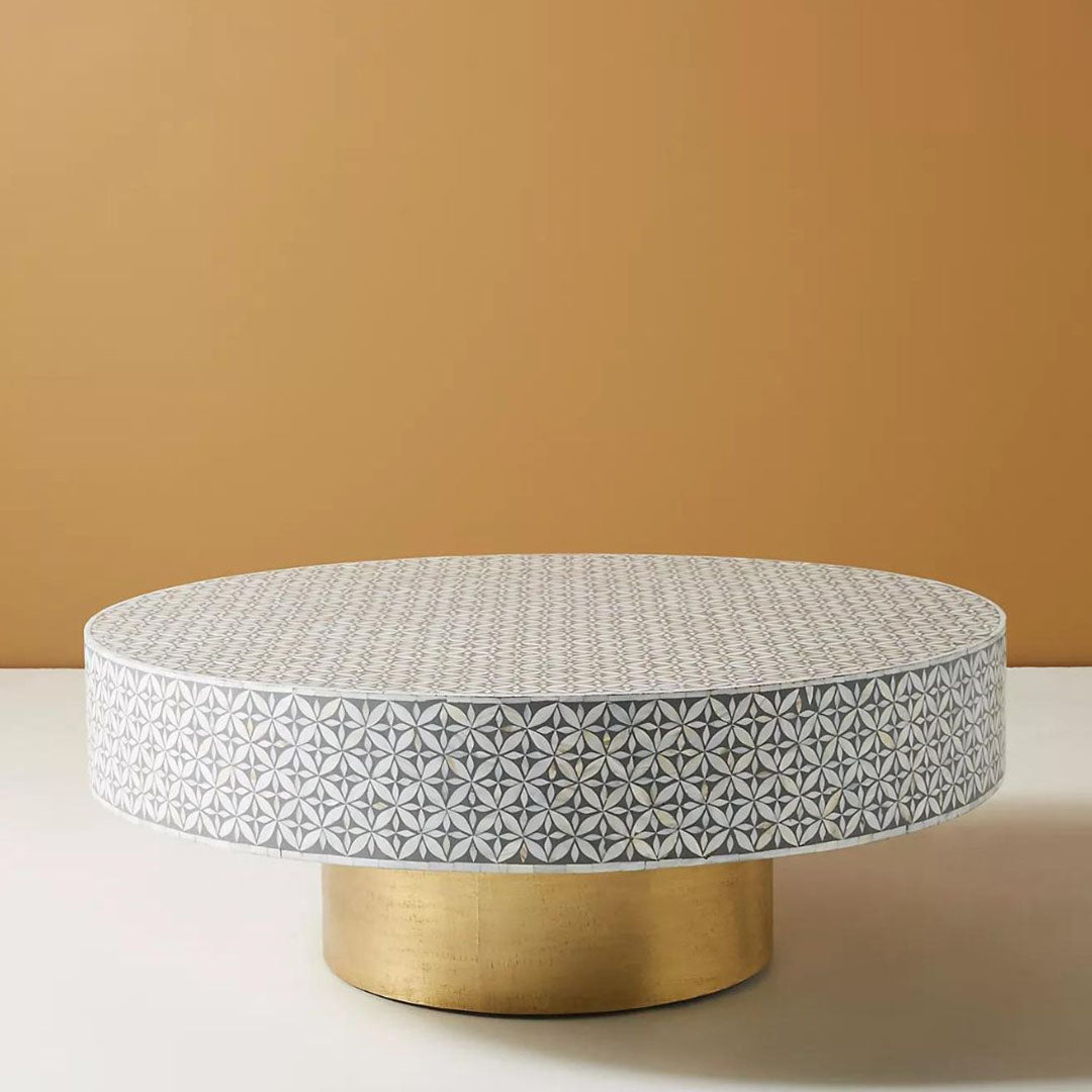 Round grey bone inlay coffee table with floral design and a bold gold base. A stylish and modern centerpiece for any living room.