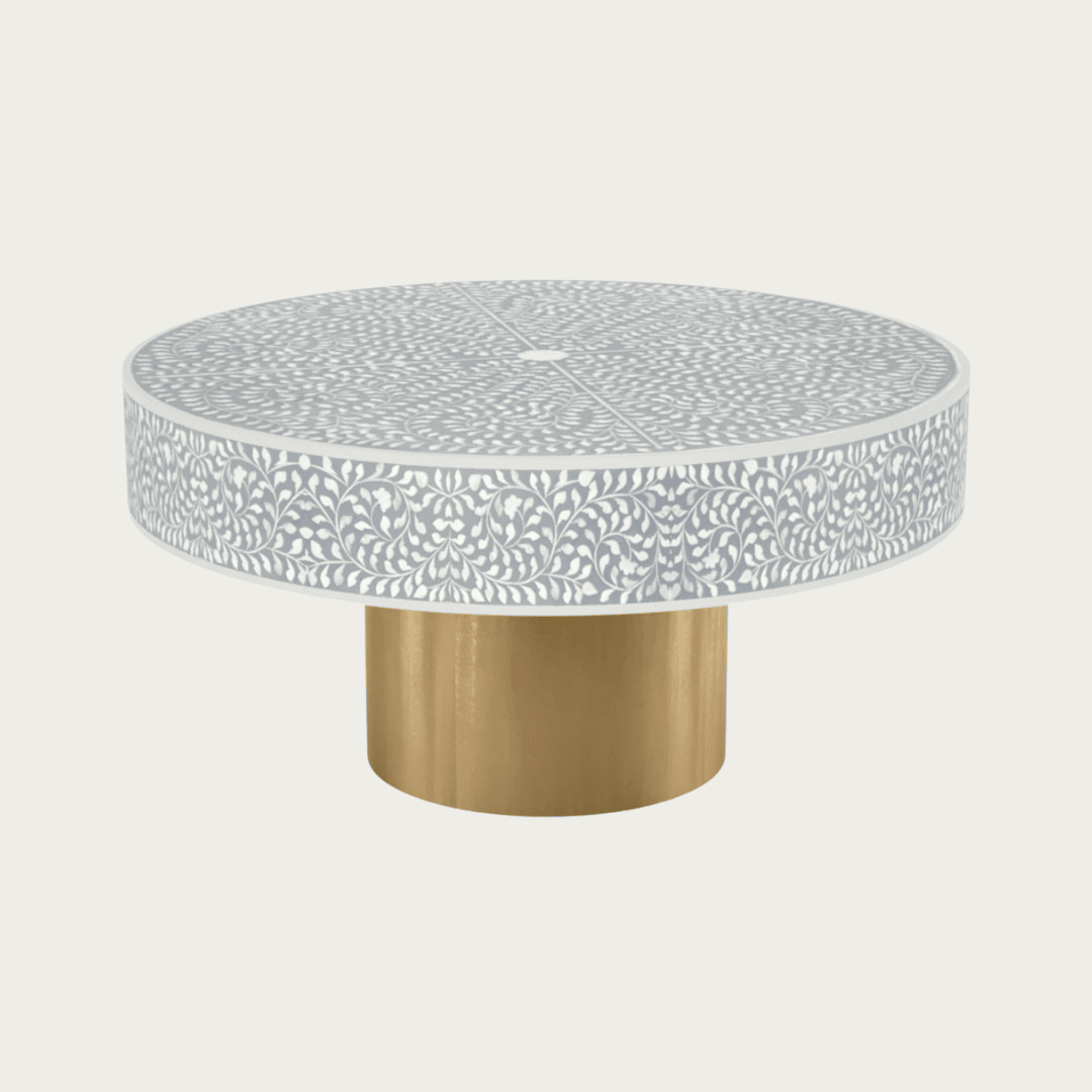Round grey bone inlay coffee table featuring an intricate floral pattern and a bold gold base