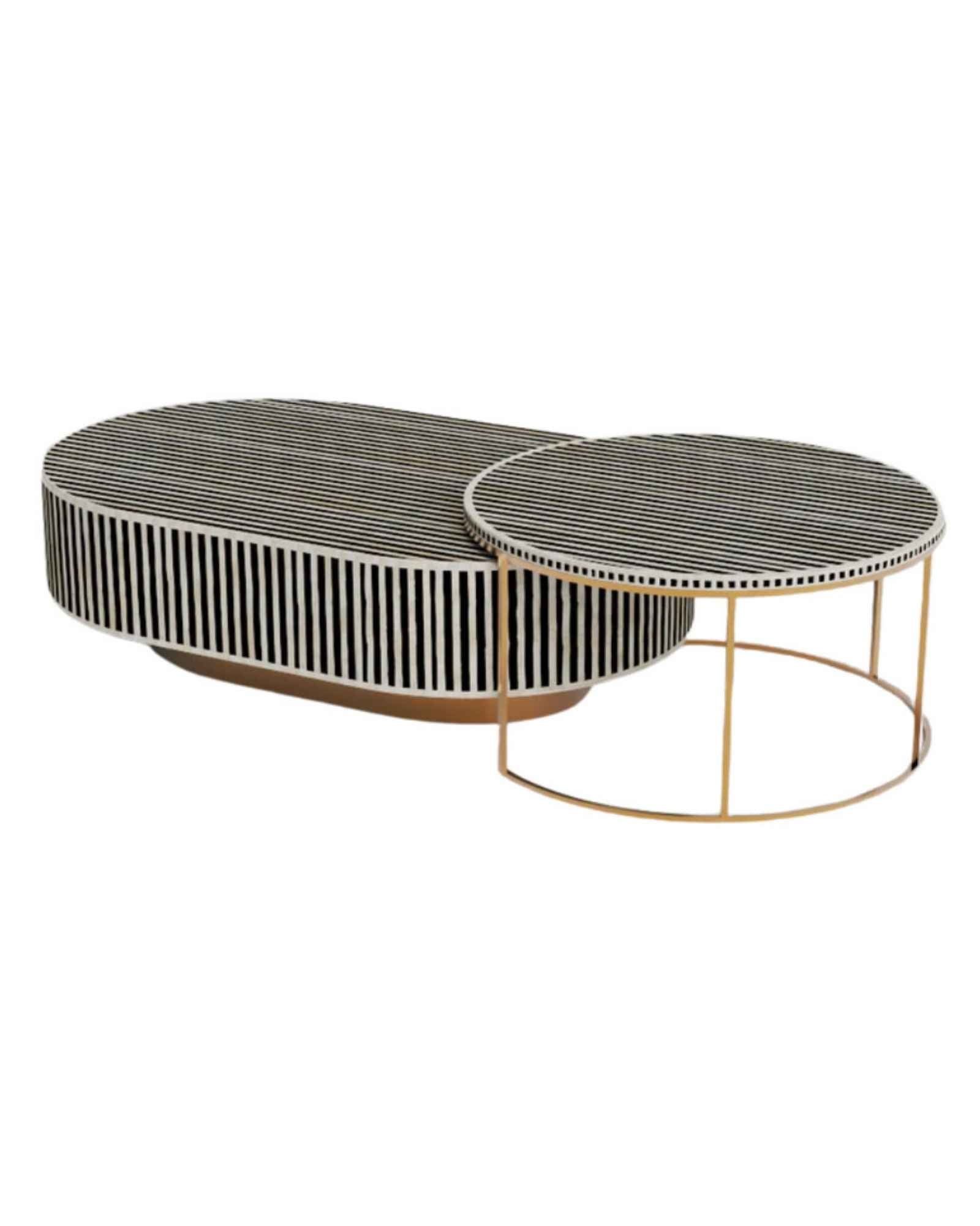 Black bone inlay nesting coffee table with vertical striped pattern and gold base, styled in a modern living room.