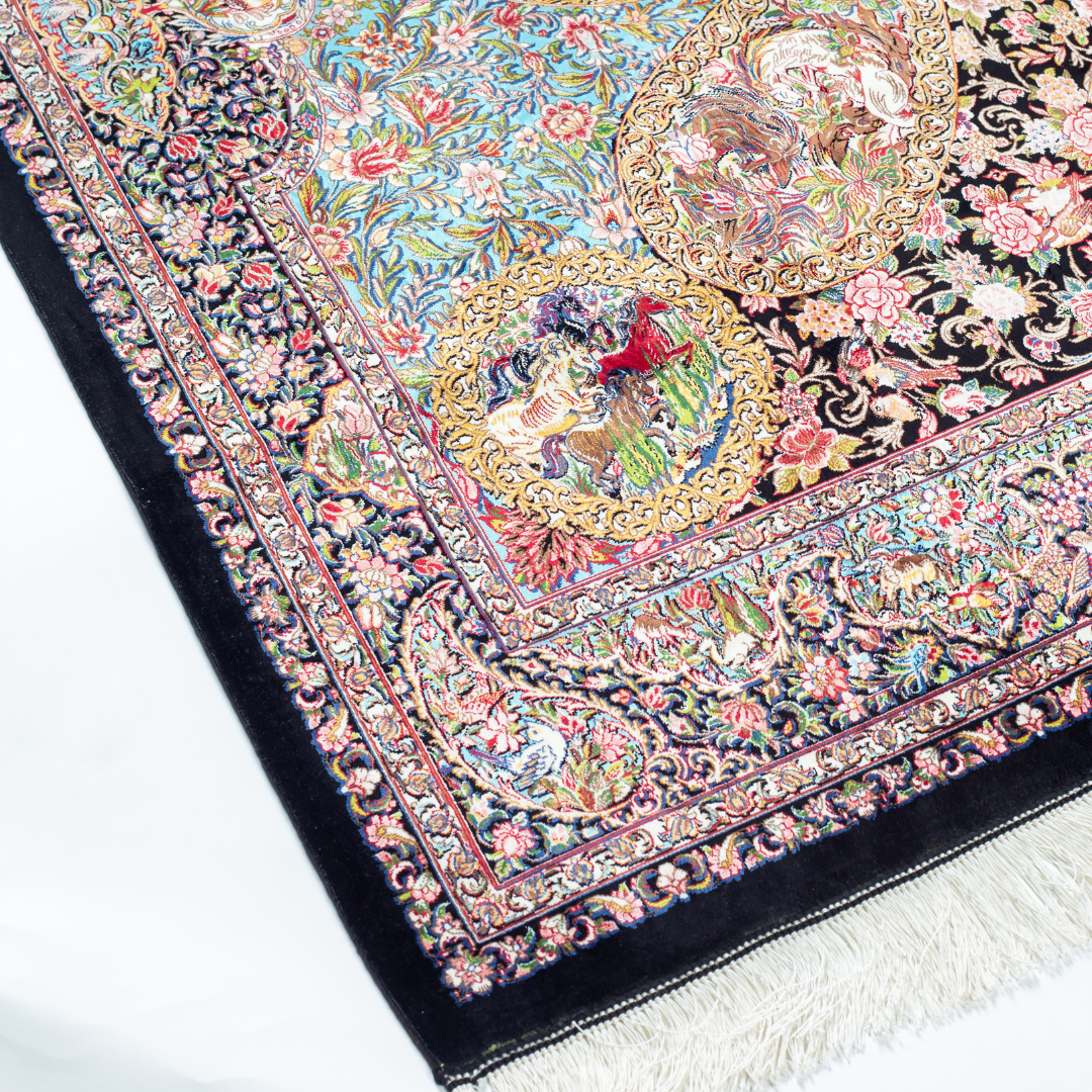 Close-up of the Sevi Persian silk rug featuring a floral and bird pattern in navy, turquoise, and gold tones. 150x100 cm size.