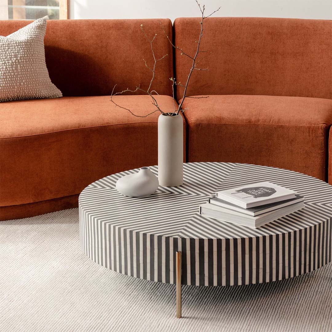 Round black bone inlay coffee table with striped design and brass legs