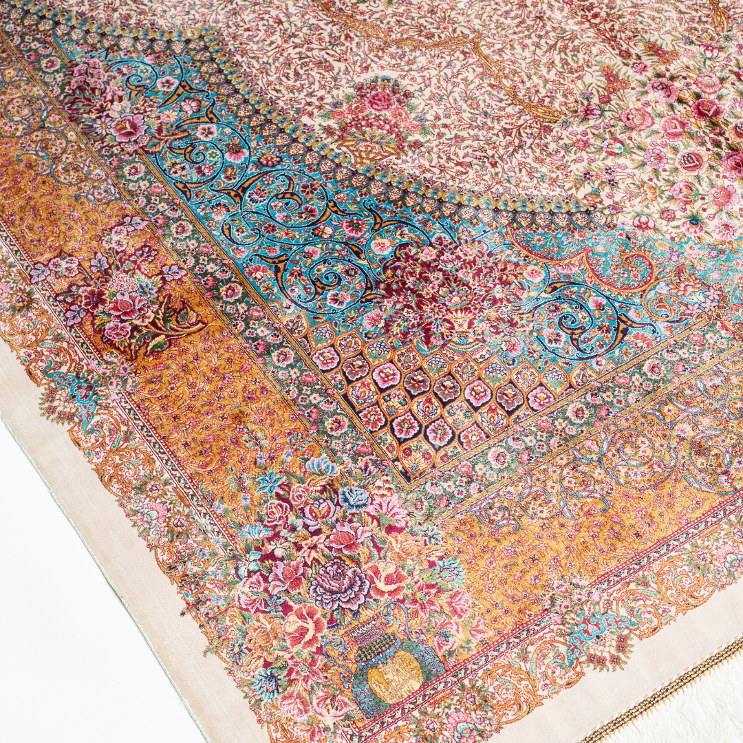 Silk Persian rug with a floral rosette medallion, ivory base, and ornate border in saffron, turquoise, plum, and blush tones.