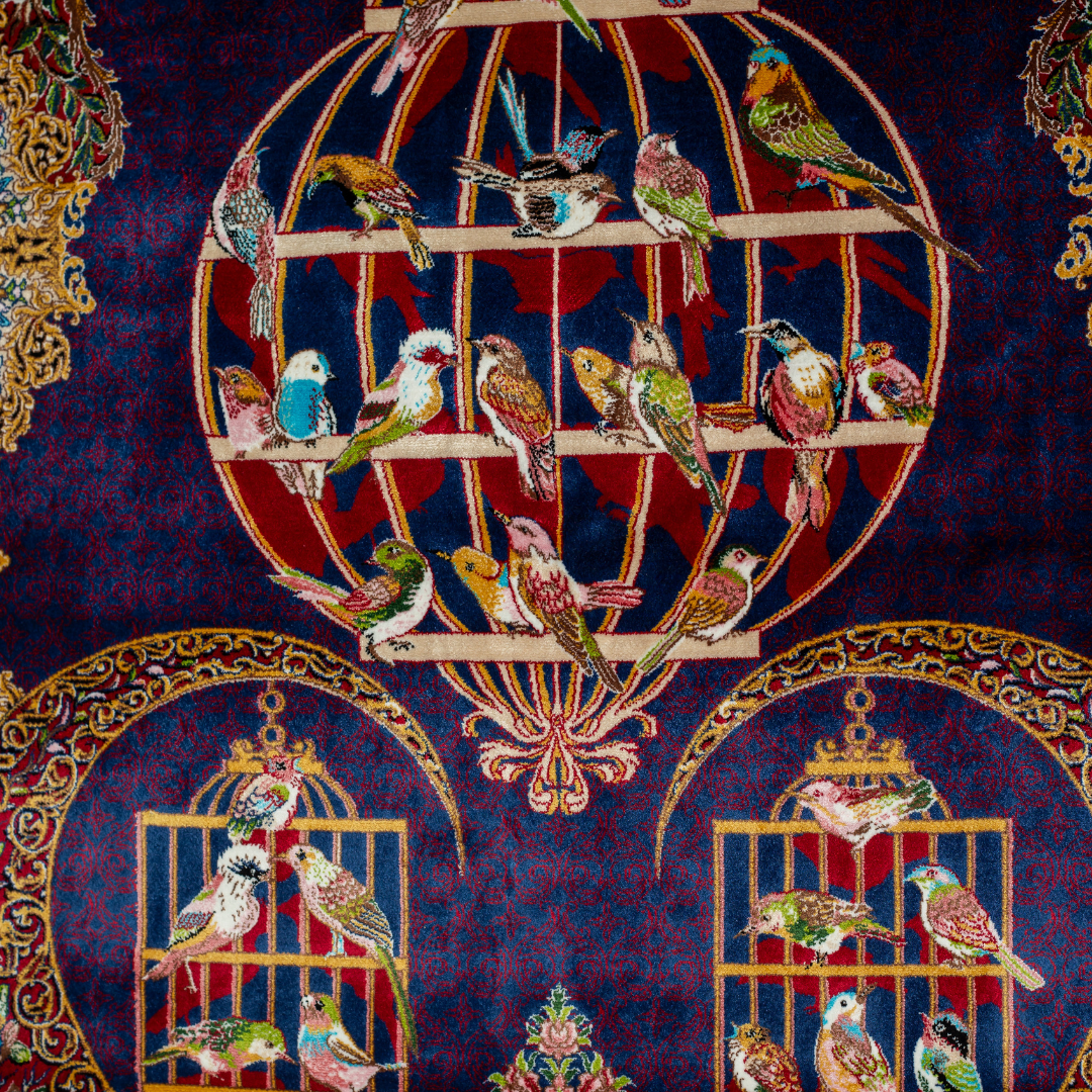 Vida silk rug with navy base, multi-colour birdcage motifs, floral accents, and detailed animal and garden scenes in 150x100 cm size.