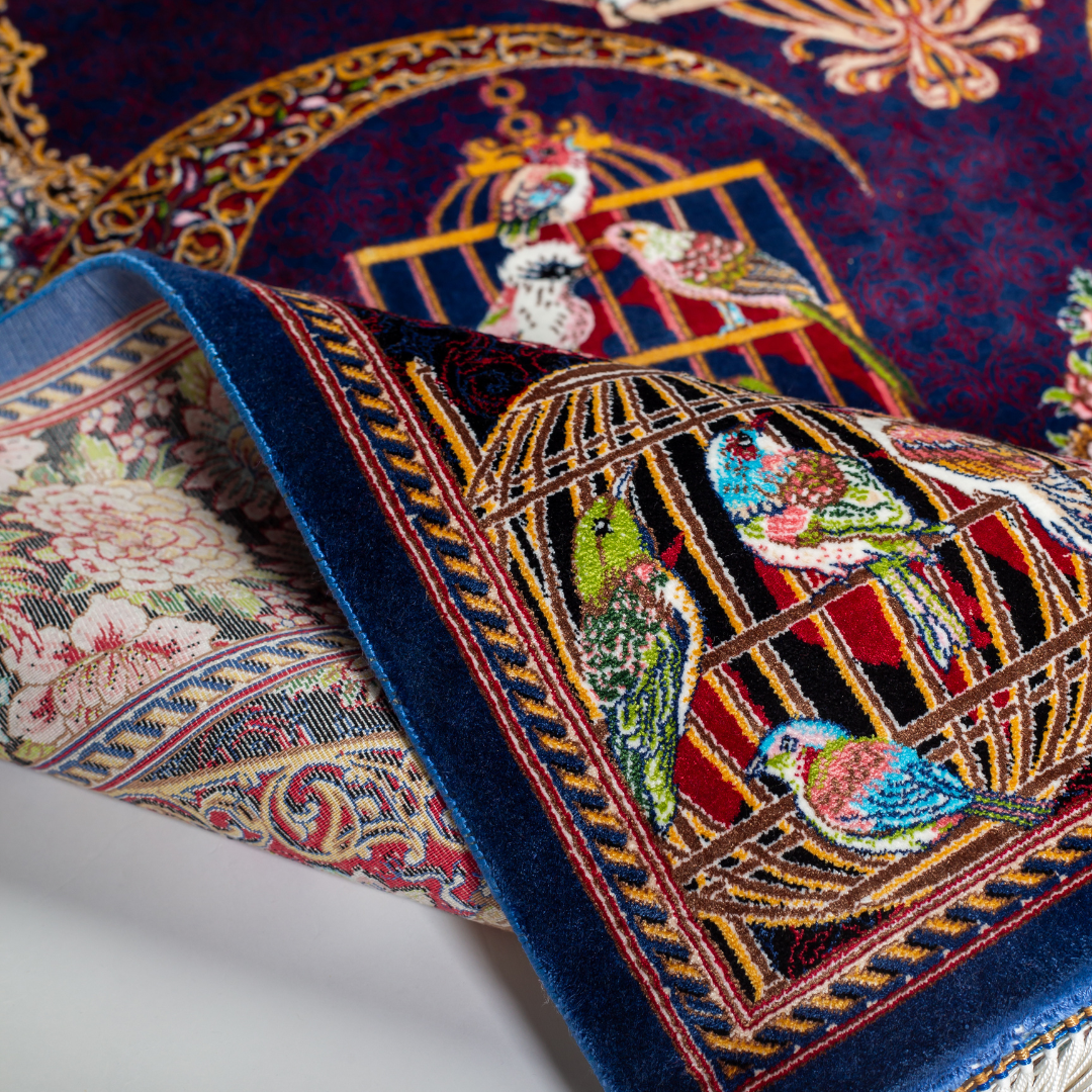 Vida silk rug with navy base, multi-colour birdcage motifs, floral accents, and detailed animal and garden scenes in 150x100 cm size.
