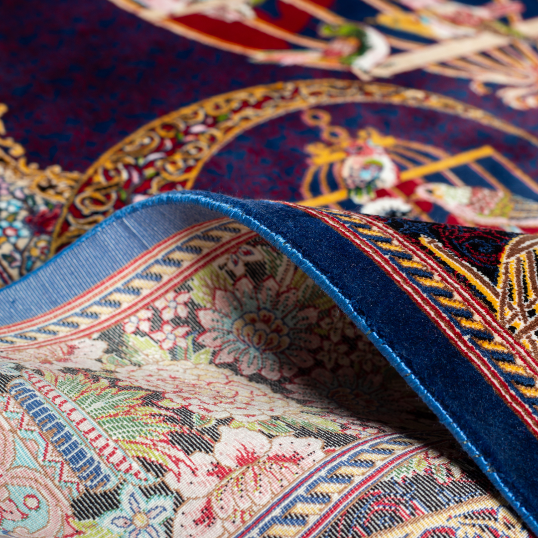 Vida silk rug with navy base, multi-colour birdcage motifs, floral accents, and detailed animal and garden scenes in 150x100 cm size.