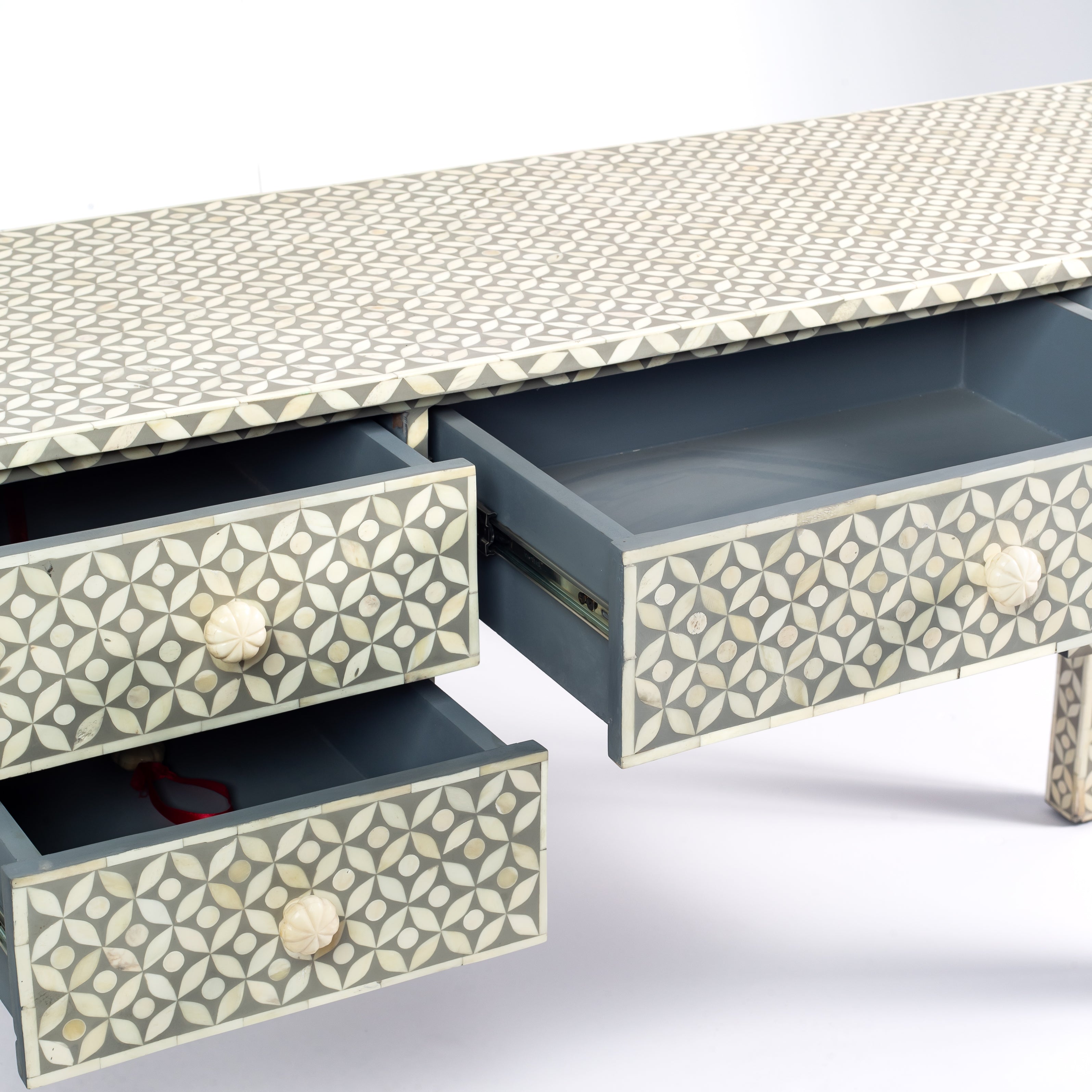 Grey bone inlay console desk with five drawers and geometric design, handcrafted with detailed knobs and artisan craftsmanship.