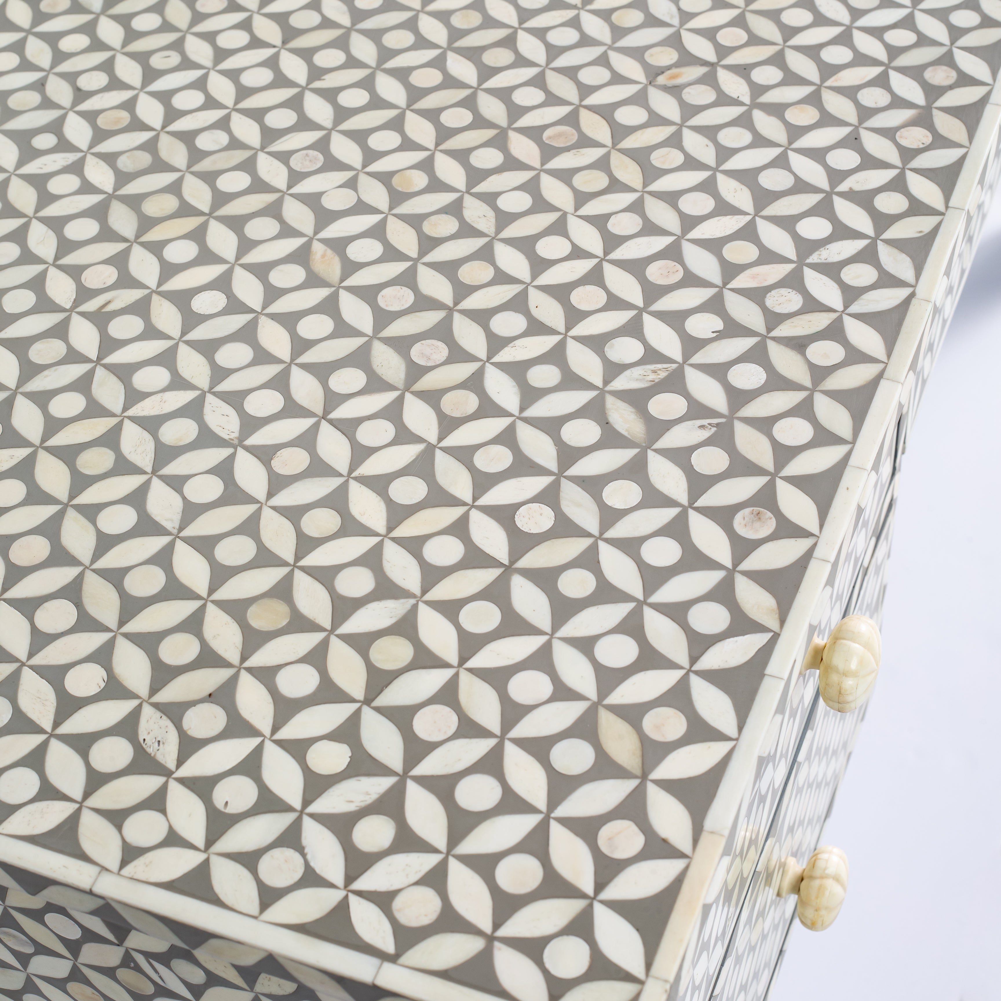 Grey bone inlay console desk with five drawers and geometric design, handcrafted with detailed knobs and artisan craftsmanship.