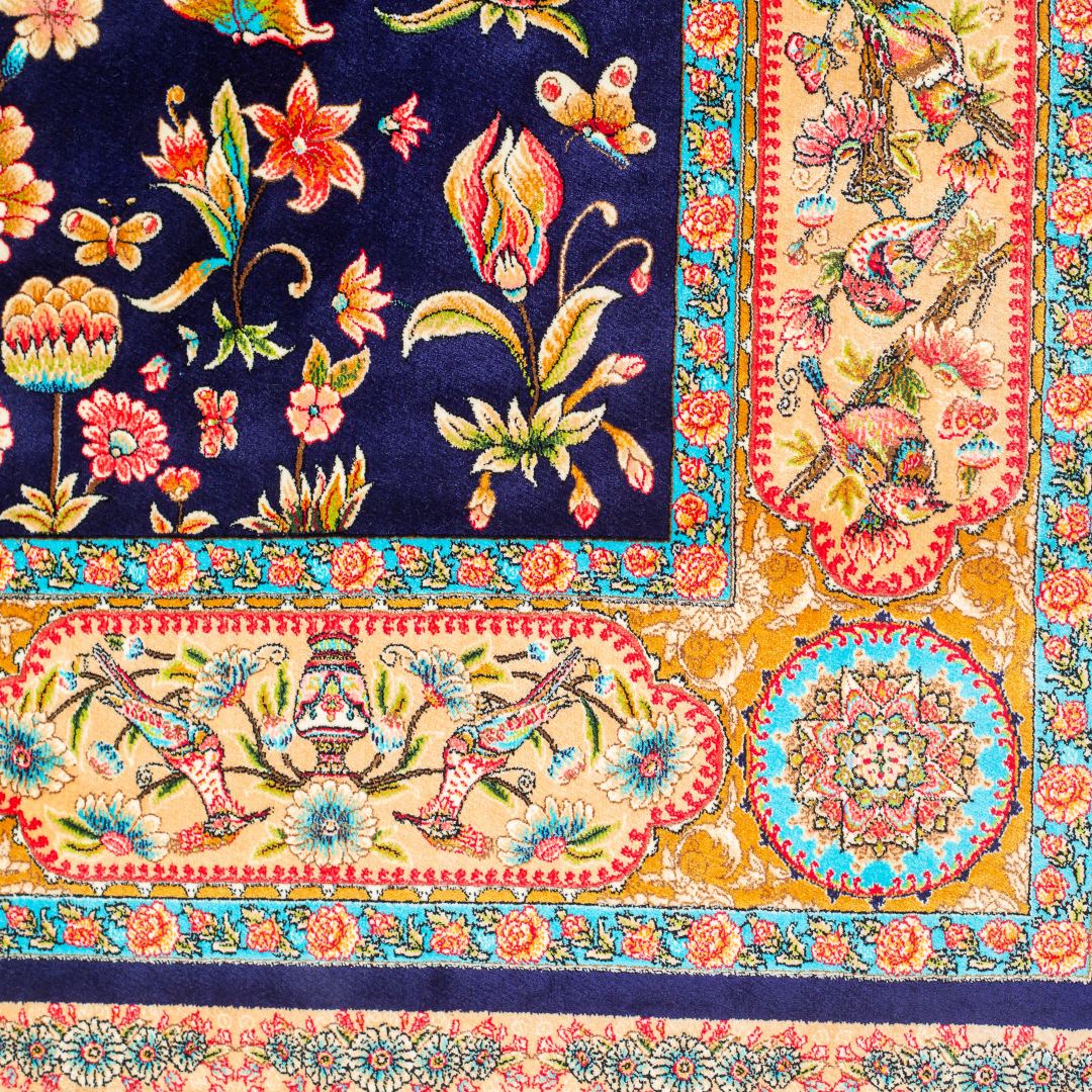 Zian silk rug featuring navy base with multi-colour florals and birds, hand-finished with detailed borders.