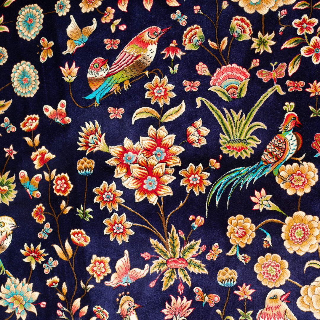 Zian silk rug featuring navy base with multi-colour florals and birds, hand-finished with detailed borders.