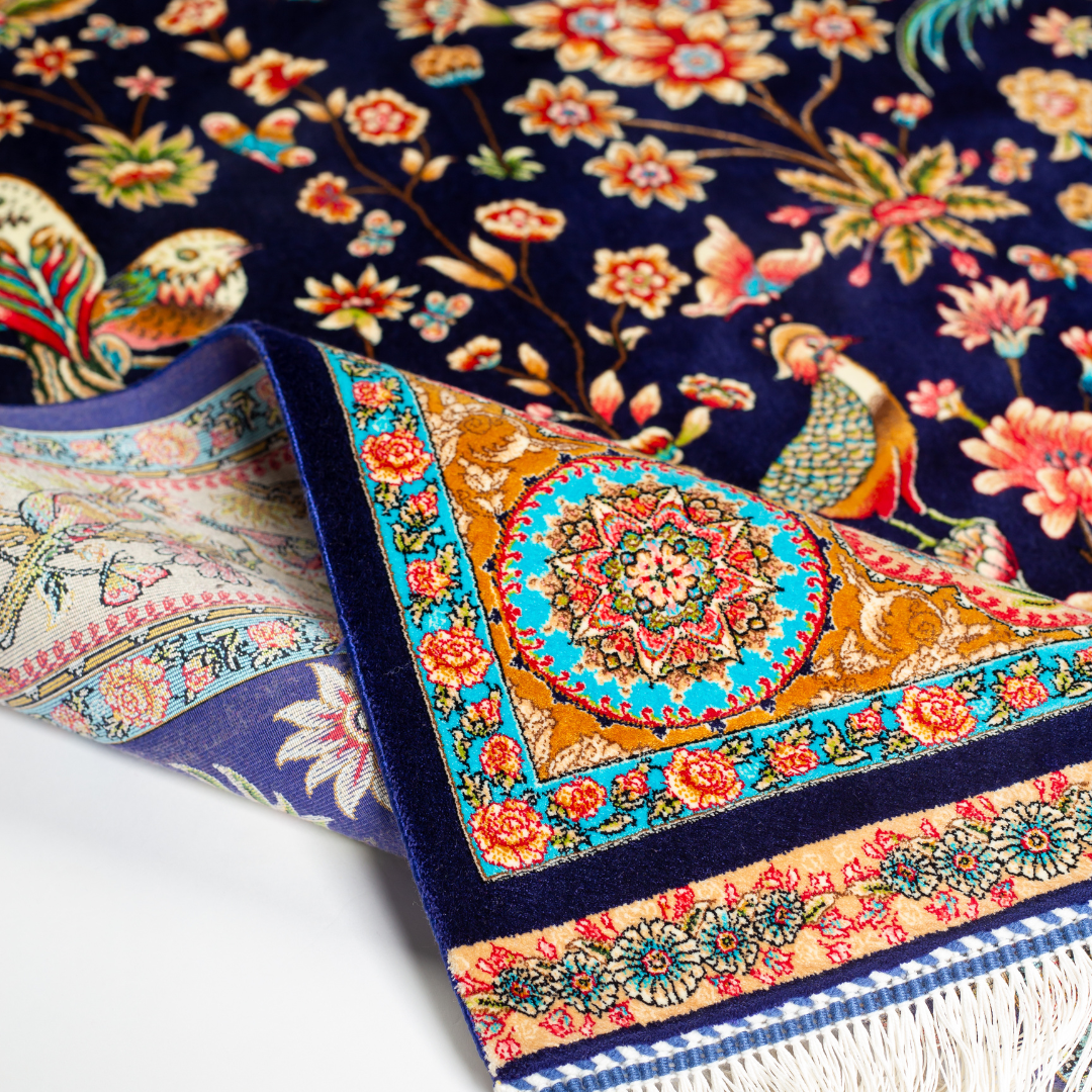 Zian silk rug featuring navy base with multi-colour florals and birds, hand-finished with detailed borders.
