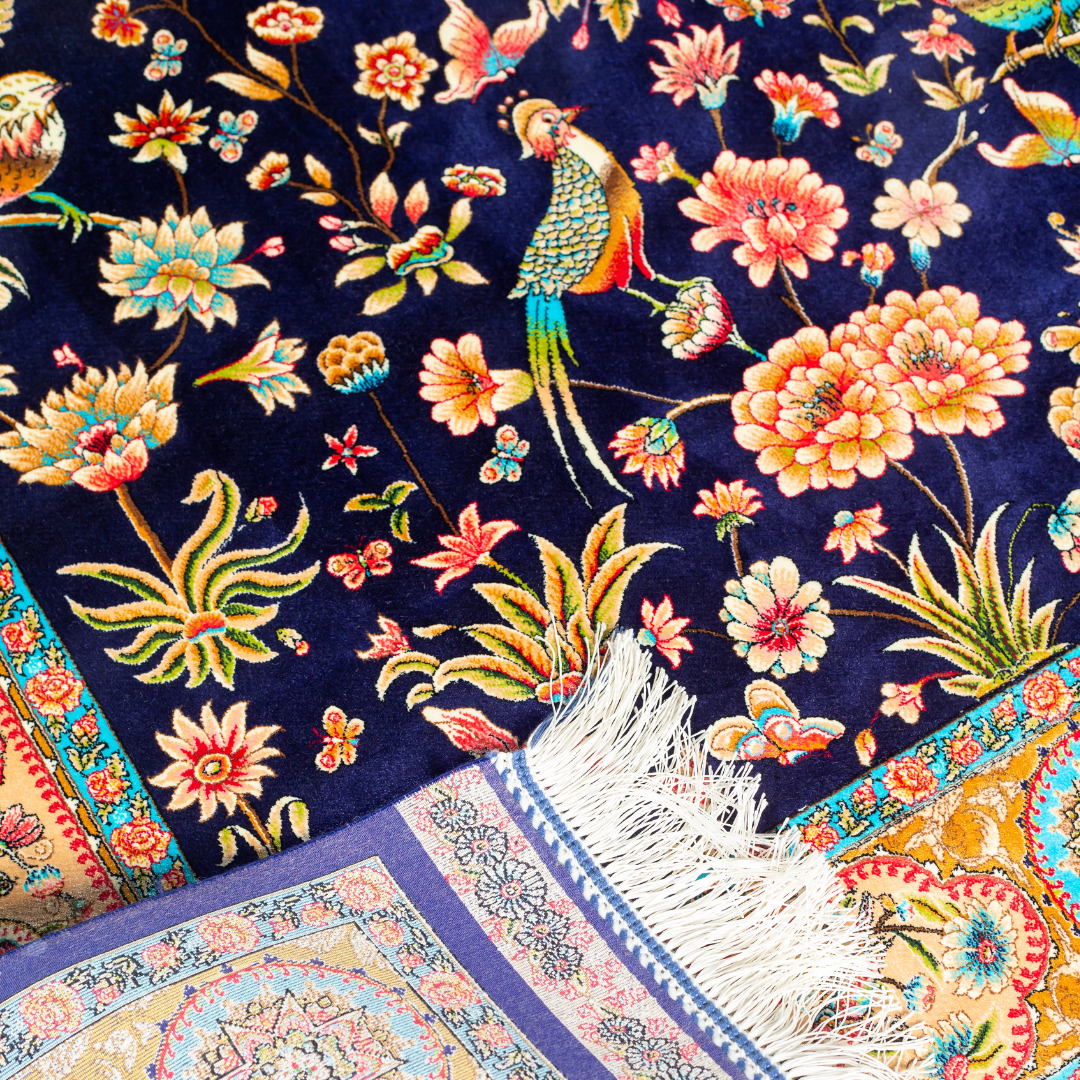 Zian silk rug featuring navy base with multi-colour florals and birds, hand-finished with detailed borders.