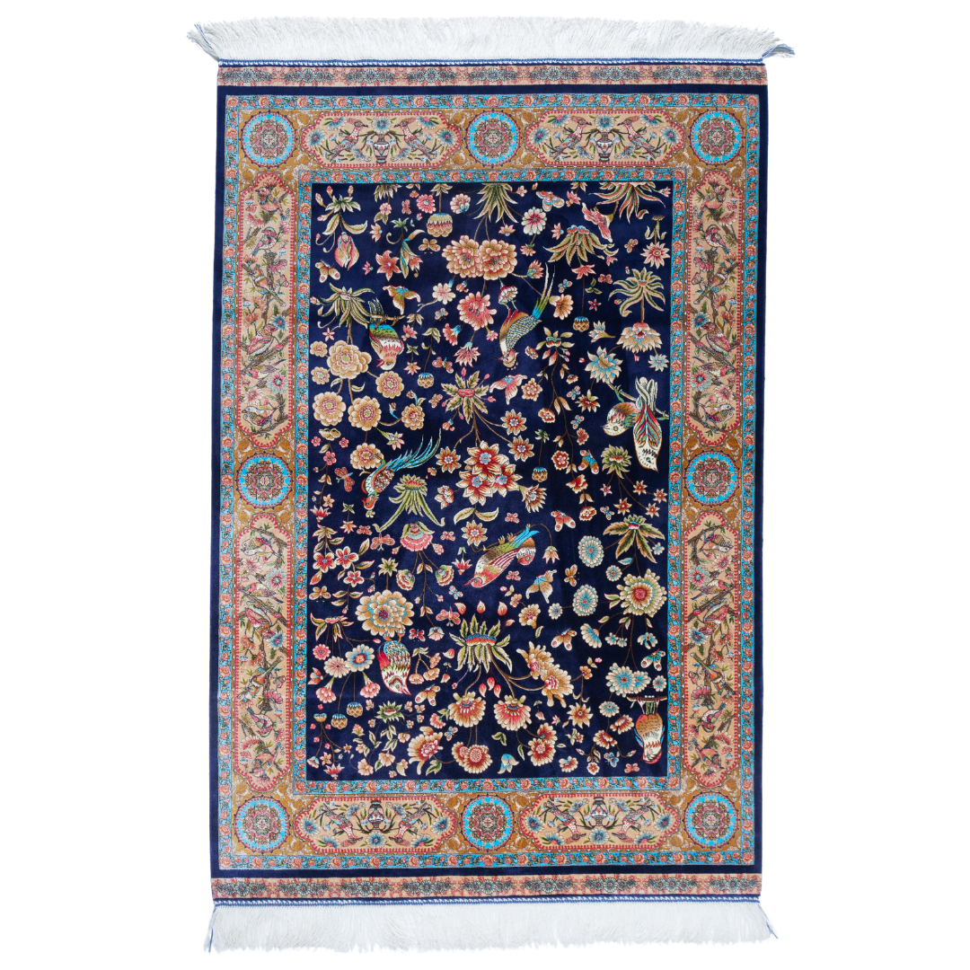 Zian silk rug featuring navy base with multi-colour florals and birds, hand-finished with detailed borders.