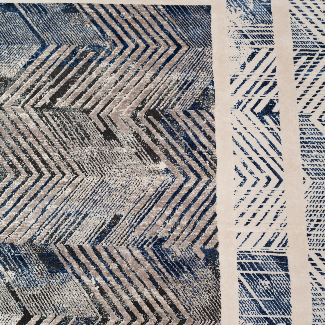 Zira cotton rug featuring a bold chevron pattern in grey, blue, and ivory with a distressed texture, perfect for contemporary interiors.