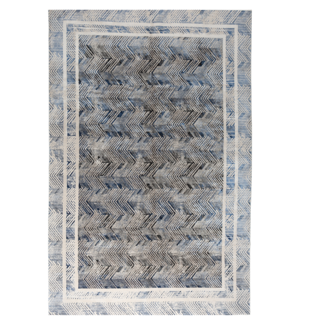 Zira cotton rug featuring a bold chevron pattern in grey, blue, and ivory with a distressed texture, perfect for contemporary interiors.