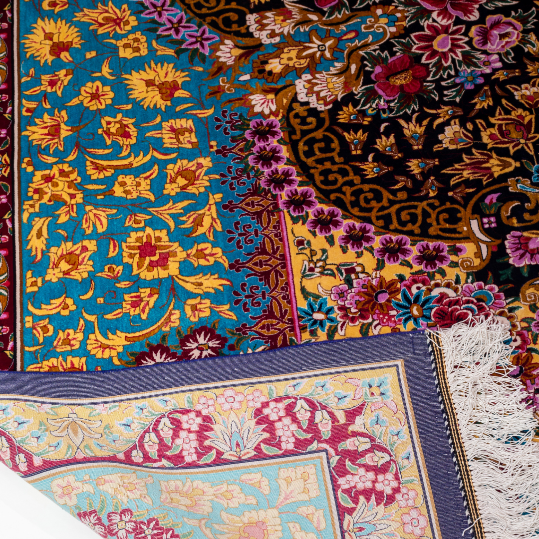 The Amorette silk rug features an ornate floral medallion over a navy base, with vivid accents of turquoise, gold, and crimson in 350x250 cm.