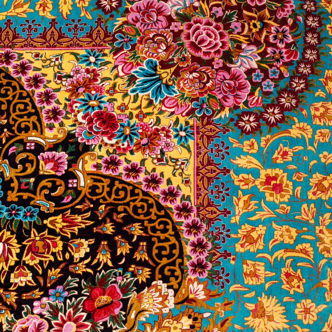 The Amorette silk rug features an ornate floral medallion over a navy base, with vivid accents of turquoise, gold, and crimson in 350x250 cm.