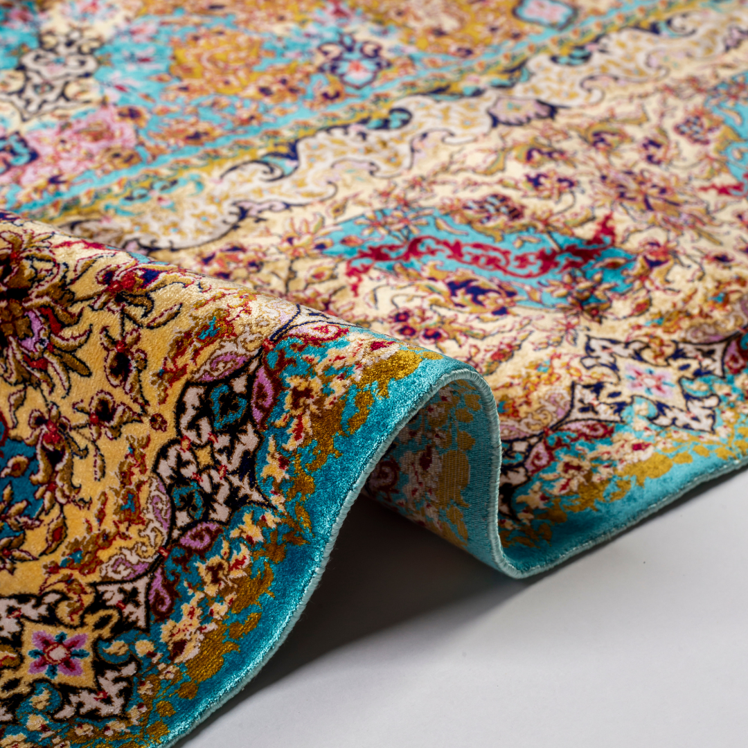 Intricately handwoven silk rug with medallion design, turquoise base, and ornate gold-maroon border for elegant interior styling.