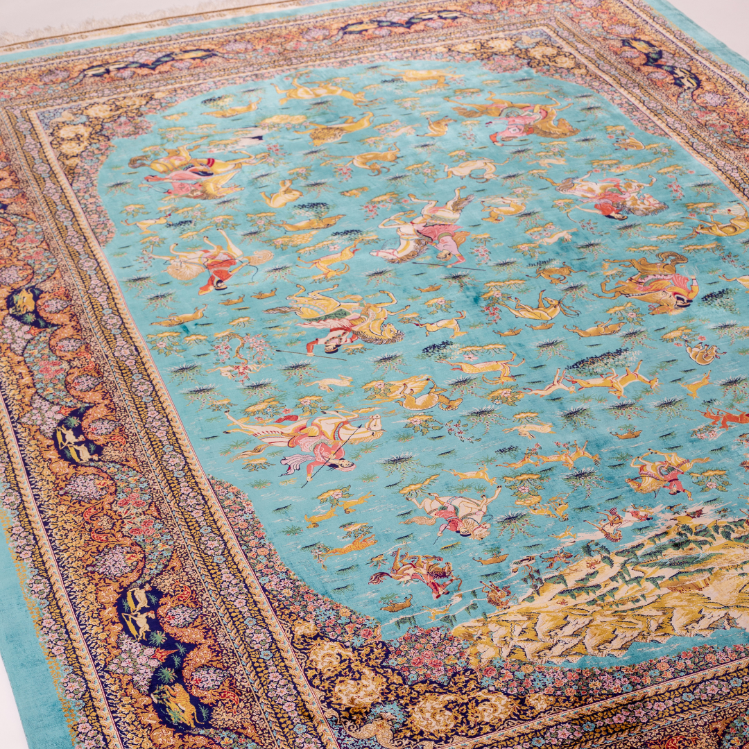 Vibrant handwoven silk rug with a turquoise base, animal motifs, hunting scenes, and floral detailing in gold and pink tones.