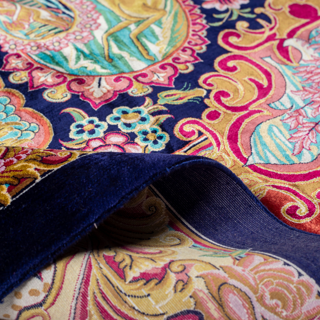 Silk rug with tree of life and bird motif, burgundy floral base, and ornate navy-gold borders. Handwoven with artistic precision.