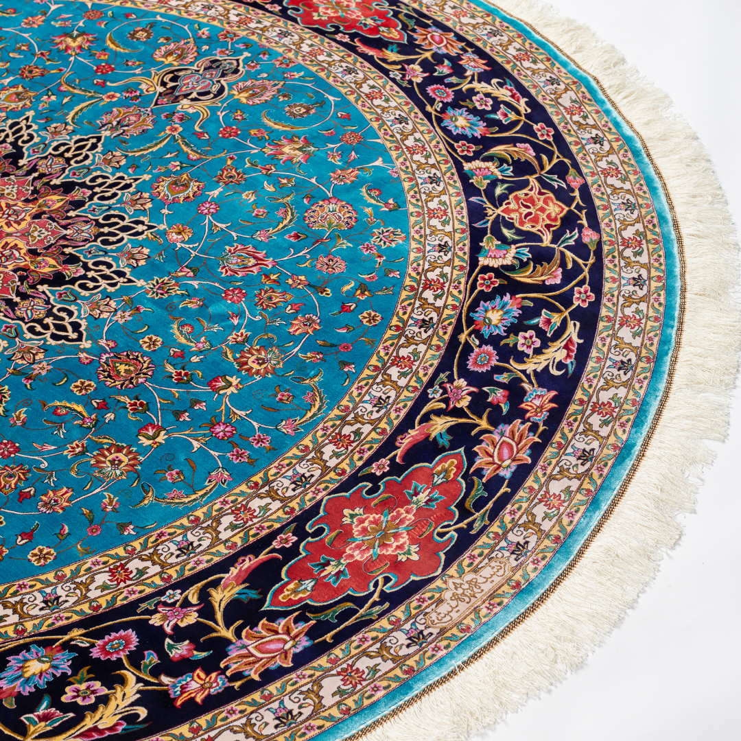 Celina Silk Rug with a turquoise base, intricate central floral medallion, and ornate navy border with Persian floral motifs and fine silk texture.