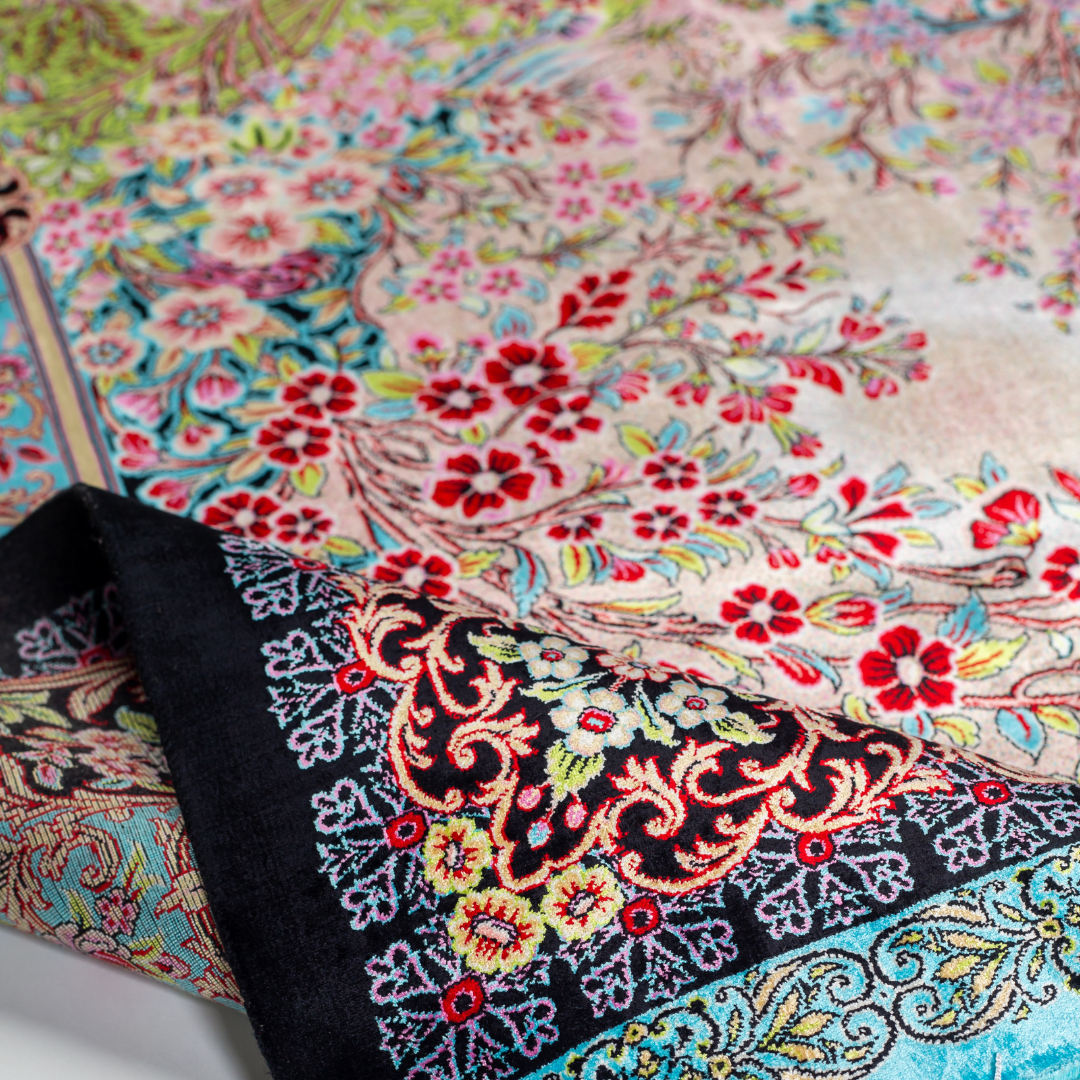 Elara Silk Rug featuring nature-inspired artwork with birds, flowers, and flowing water on an ivory base with turquoise and black borders, 150x100 cm.