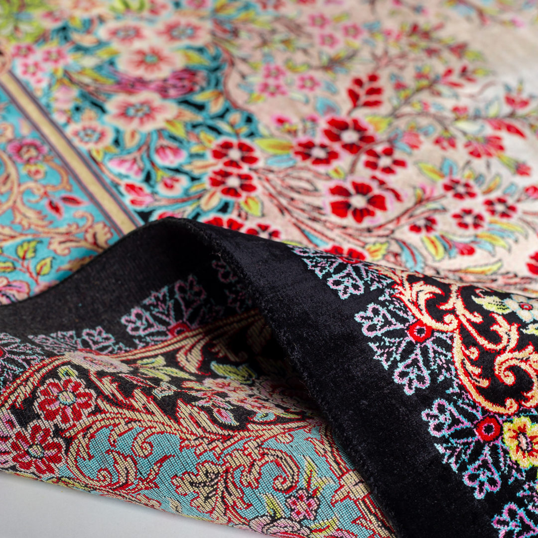 Elara Silk Rug featuring nature-inspired artwork with birds, flowers, and flowing water on an ivory base with turquoise and black borders, 150x100 cm.